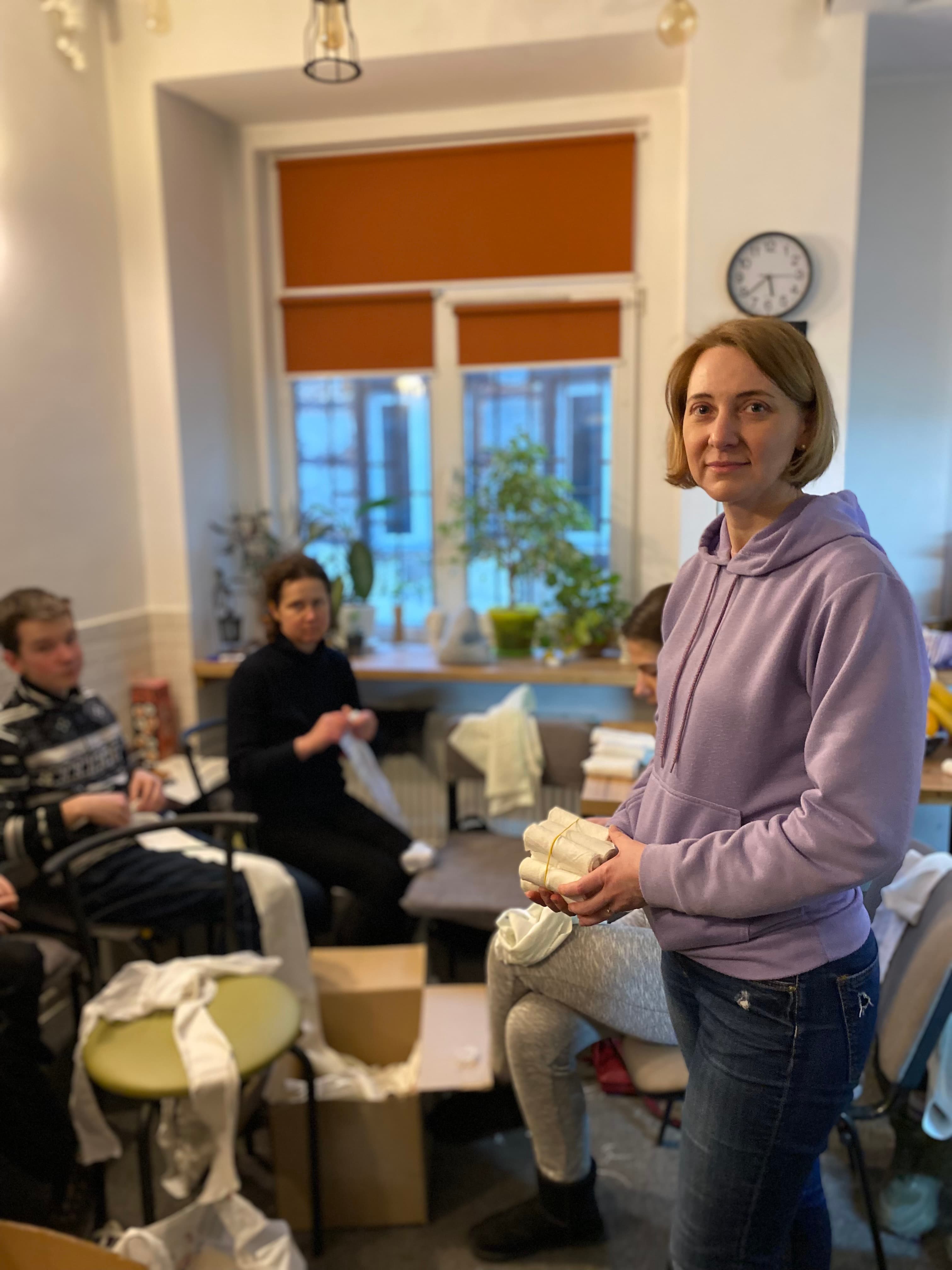 Olena Lukina in downtown Lviv, Ukraine, rips donated bed sheets and rolls them into bandages to be delivered to troops on the front line.