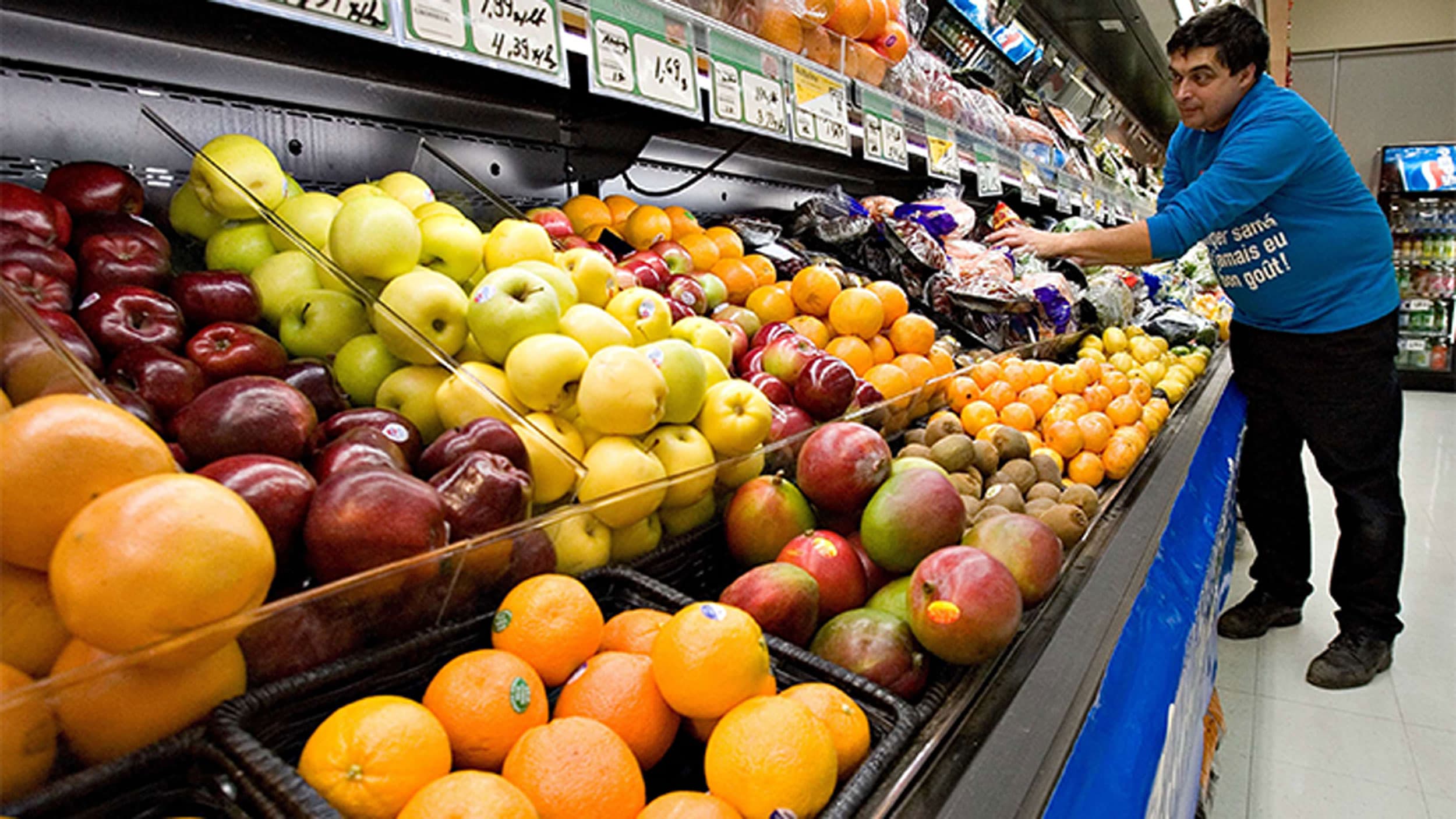 Grocery store owner Gilles Robin works on his fruits vegetable display in Levis Que, Canada
