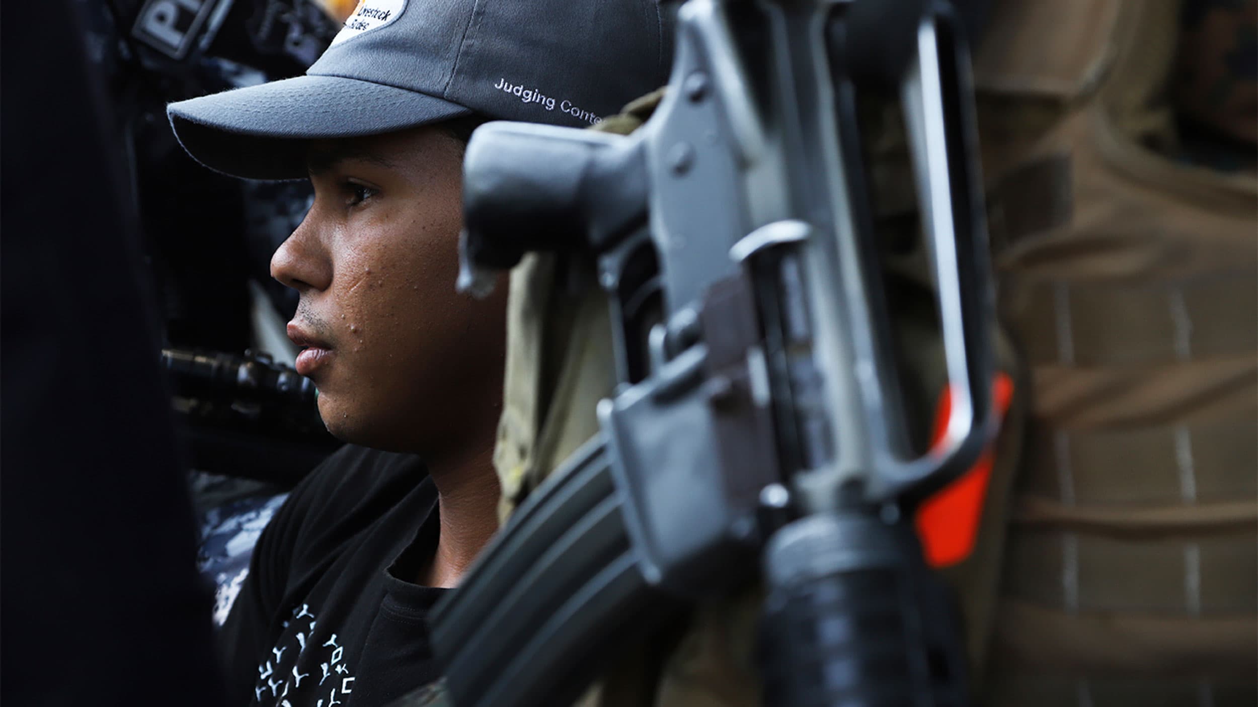 A young man is detained by the police, a suspect in a homicide near a market in San Salvador, El Salvador