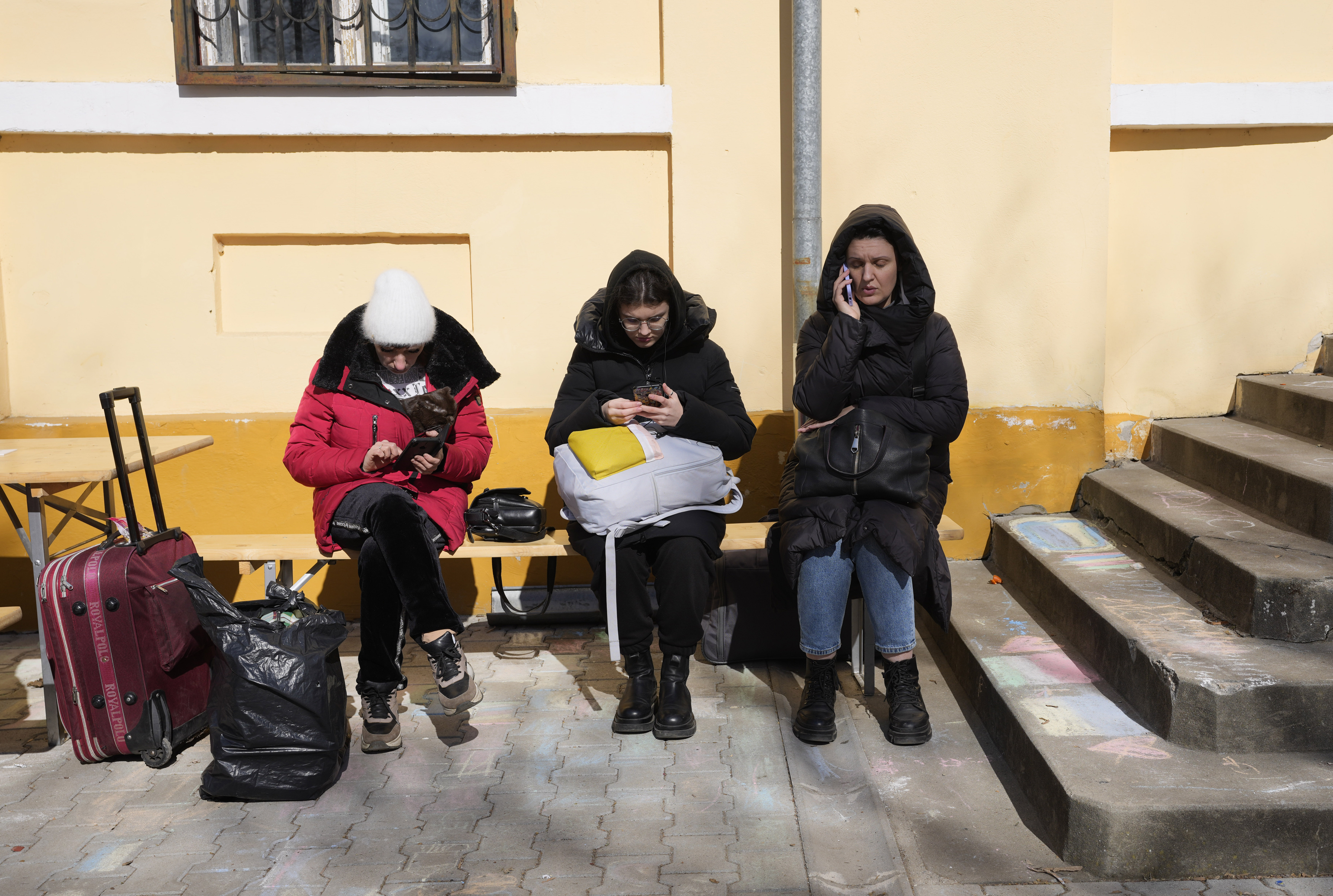 Three women displaced by the Russian invasion of Ukraine check their mobile phones at a refugee centre in Hungary.