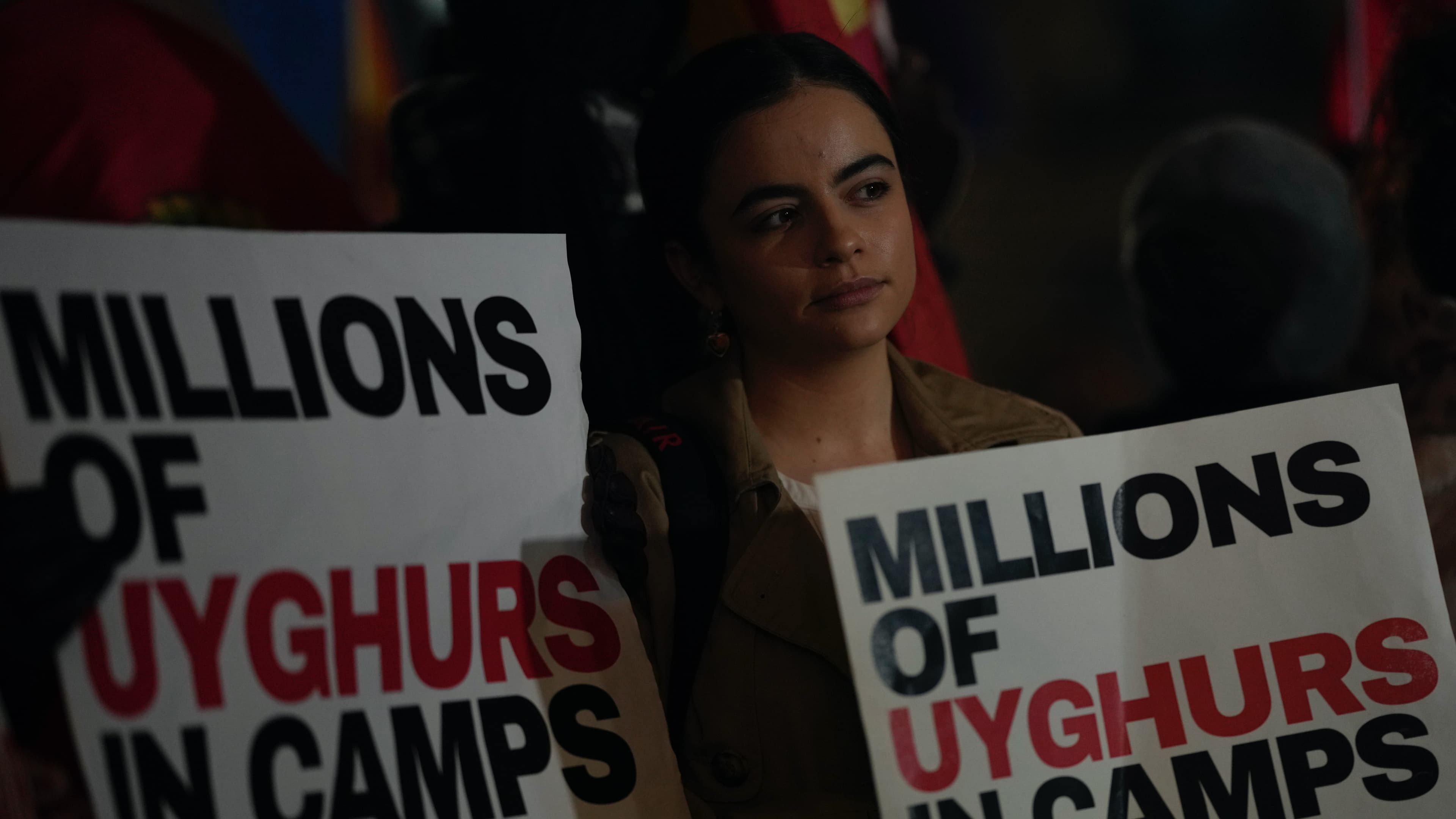 A protester holds a placard as she takes part in a small demonstration against the holding of the 2022 Winter Olympic Games in China, at Piccadilly Circus in London, Feb. 3, 2022. 