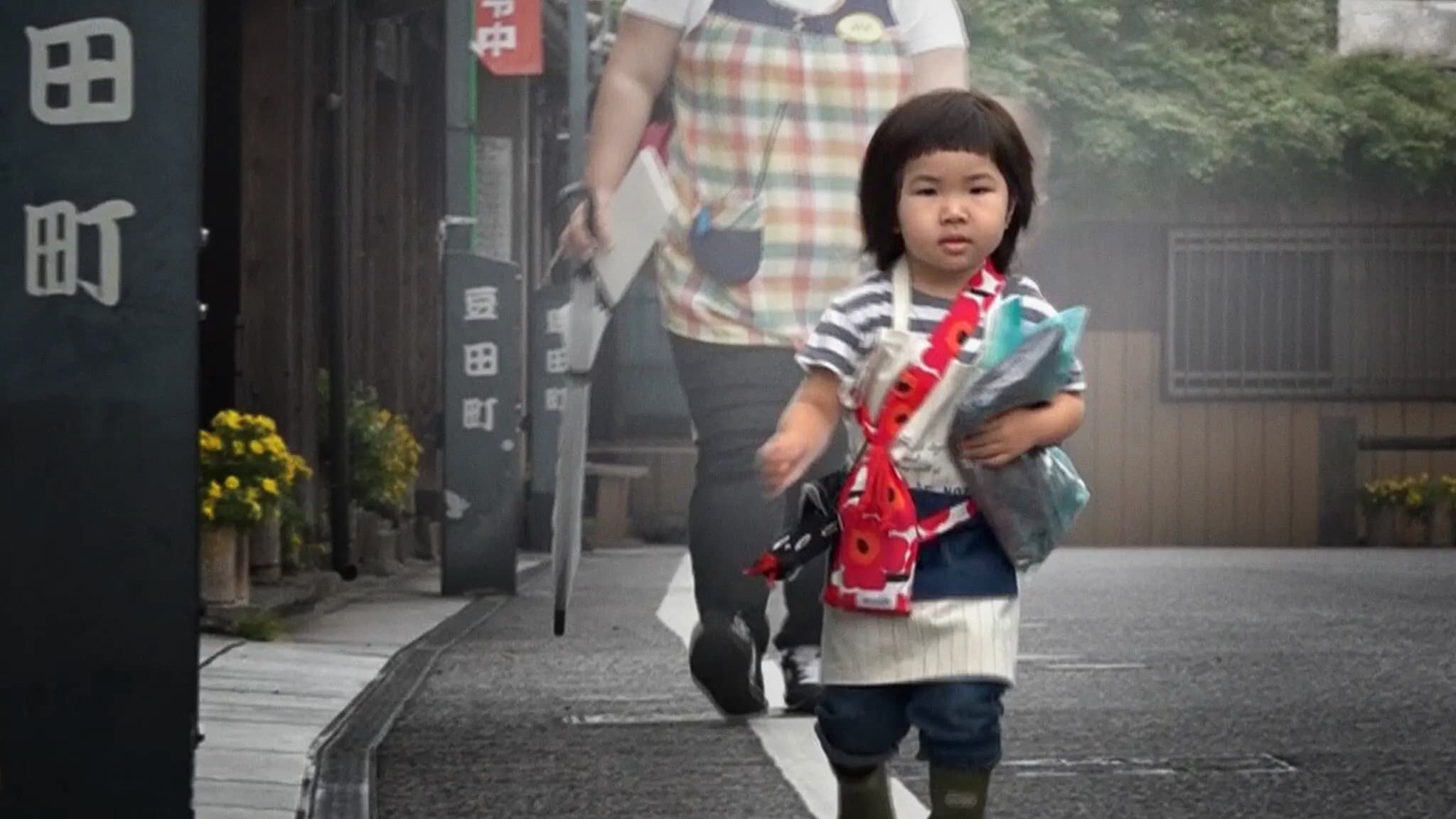 a young kid walking down the sidewalk