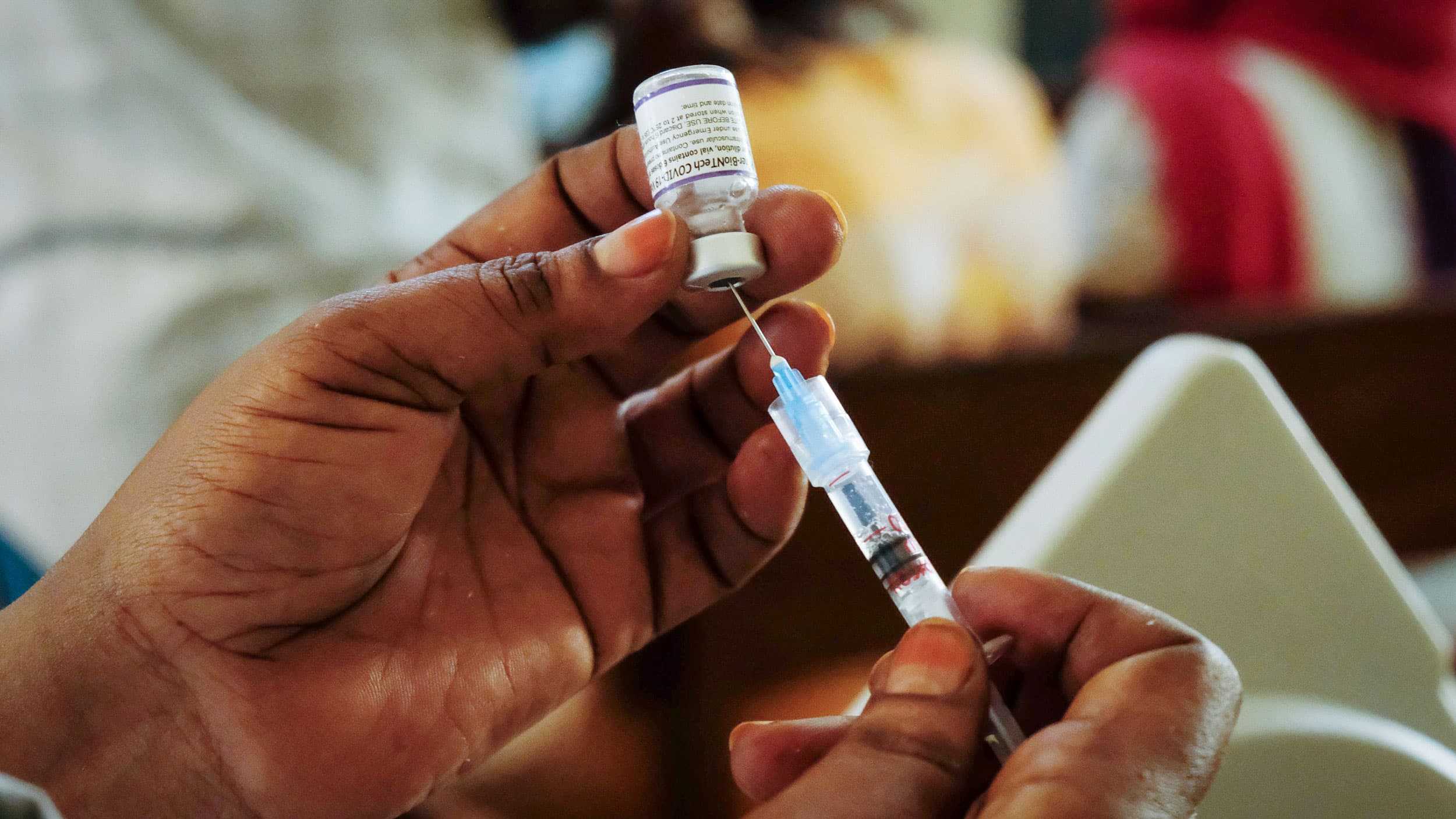 A nurse prepares a Pfizer coronavirus vaccination at the Kiswa Health Center III in the Bugolobi neighborhood of Kampala, Uganda Tuesday, Feb. 8, 2022. 