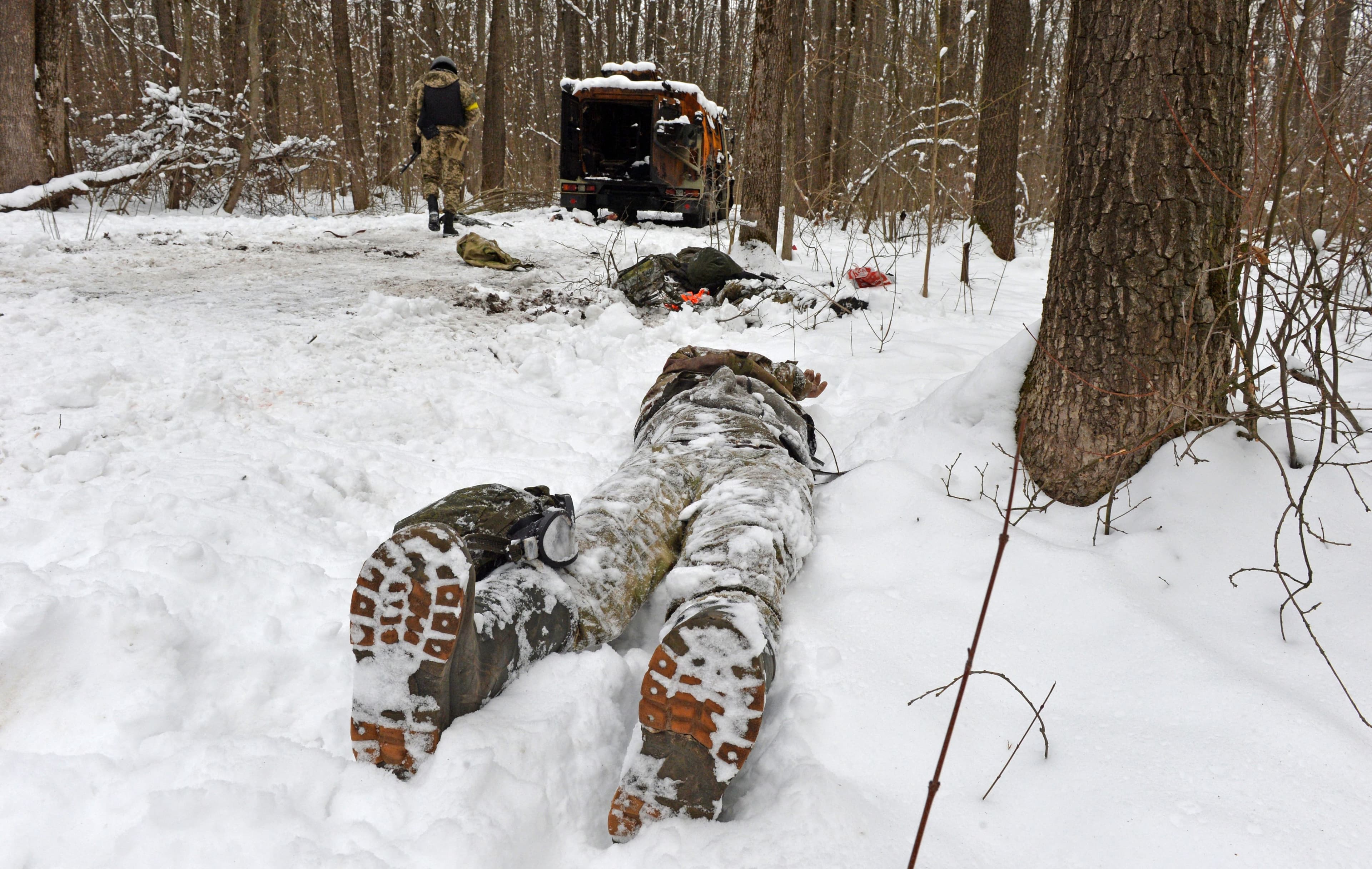 The body of a serviceman near a destroyed Russian military vehicle.