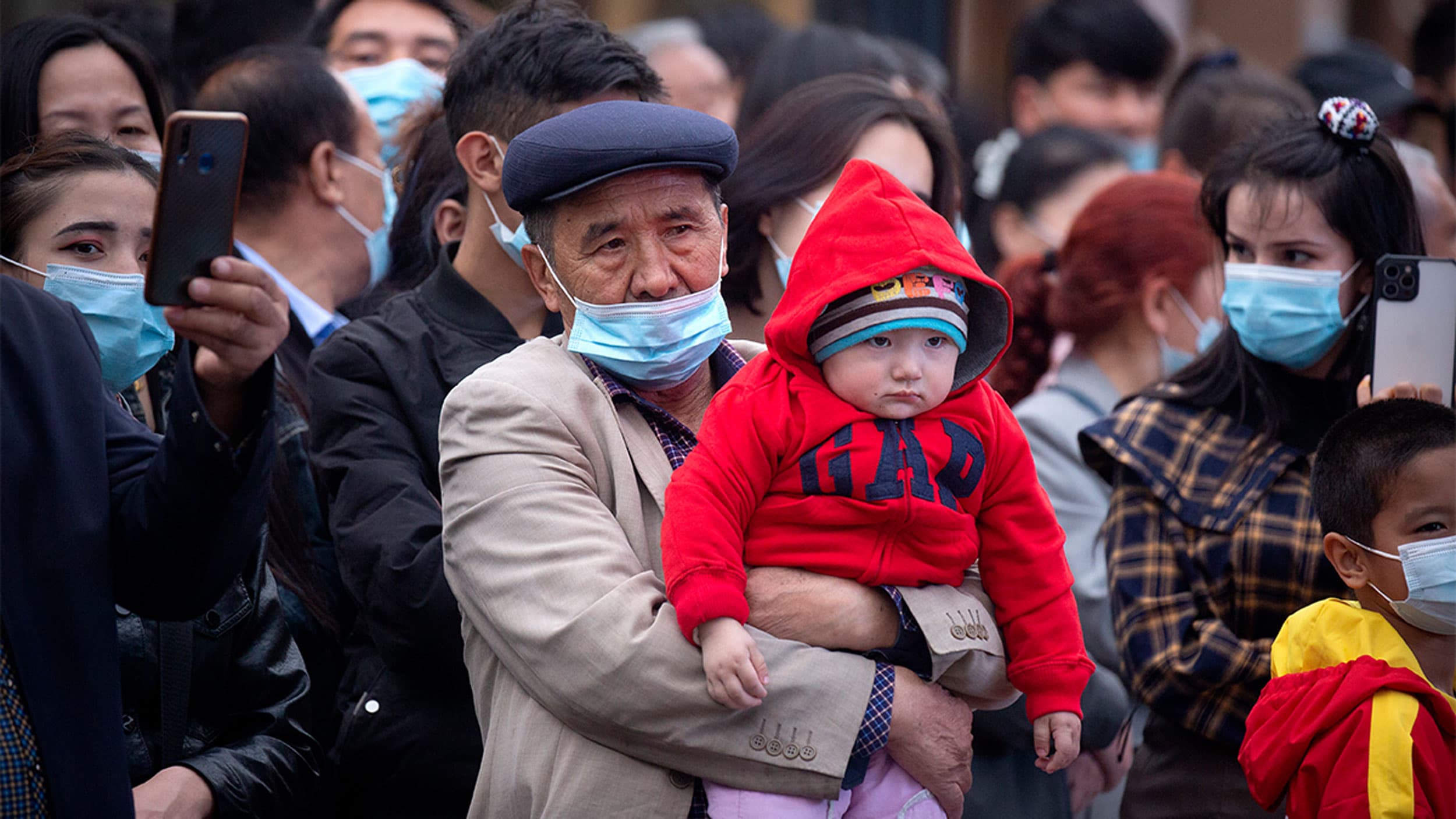 A man holds a child as they watch a dance performance at the International Grand Bazaar in Urumqi in western China's Xinjiang Uyghur Autonomous Region