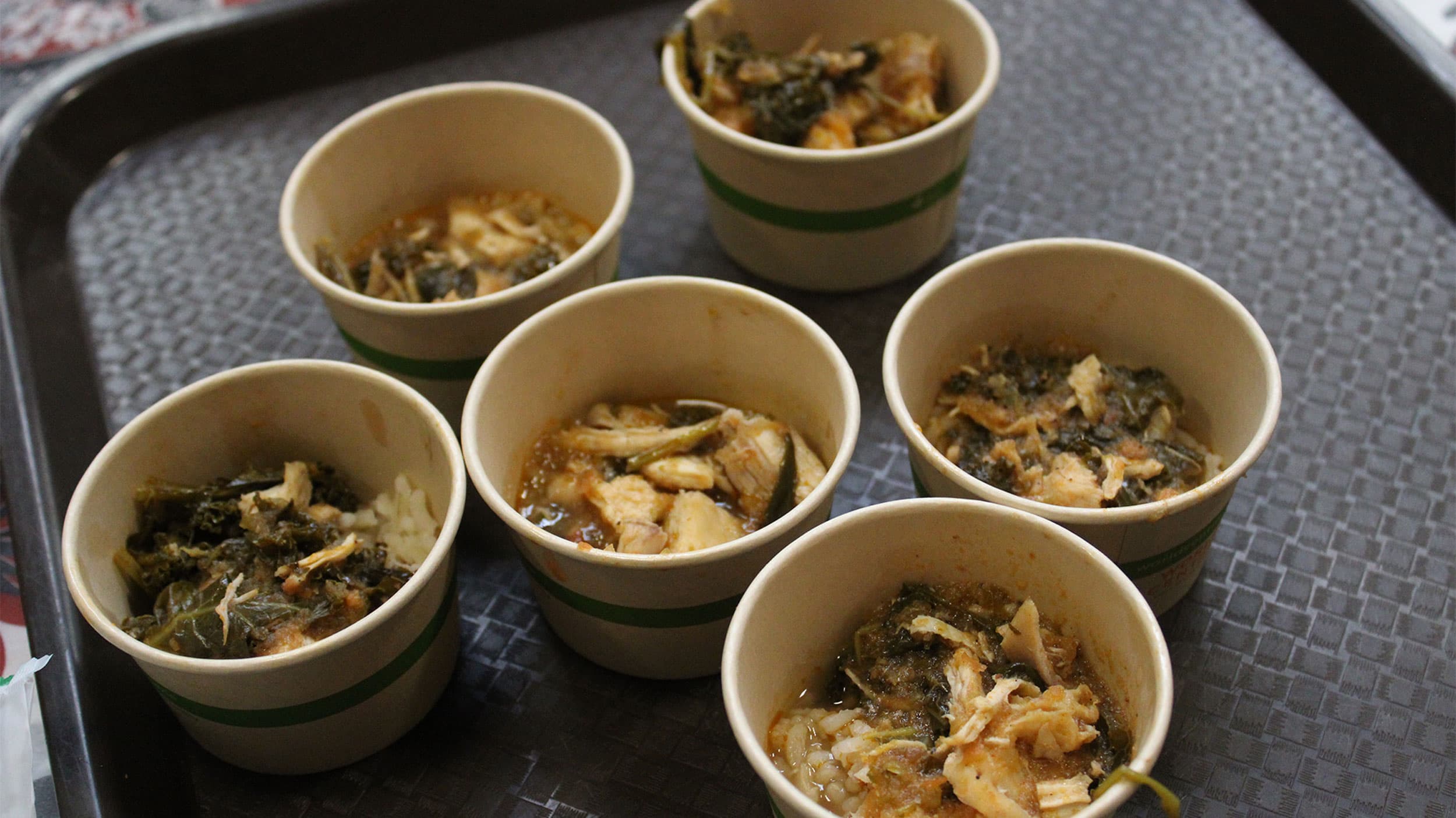 Sample portions of chicken and kale stew over rice