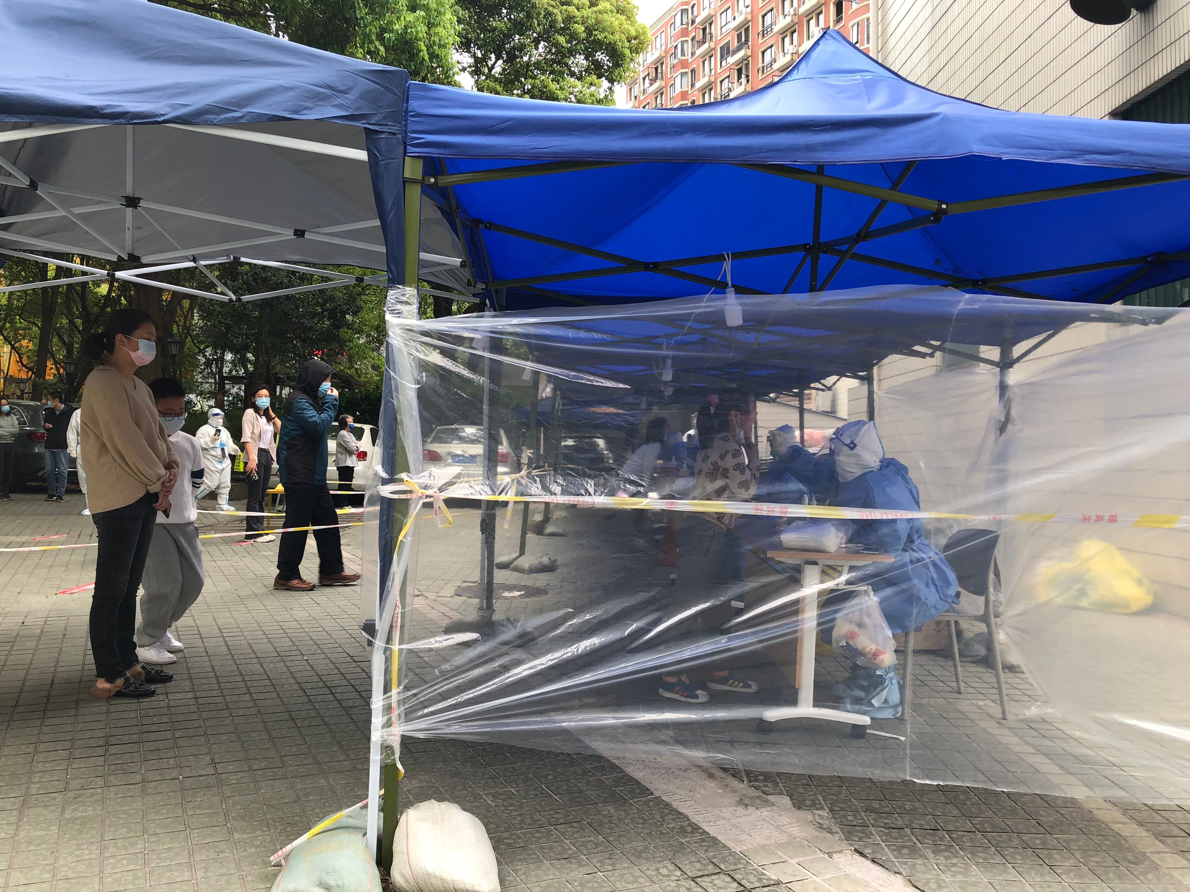 People line up to get tested for COVID-19 in an apartment compound