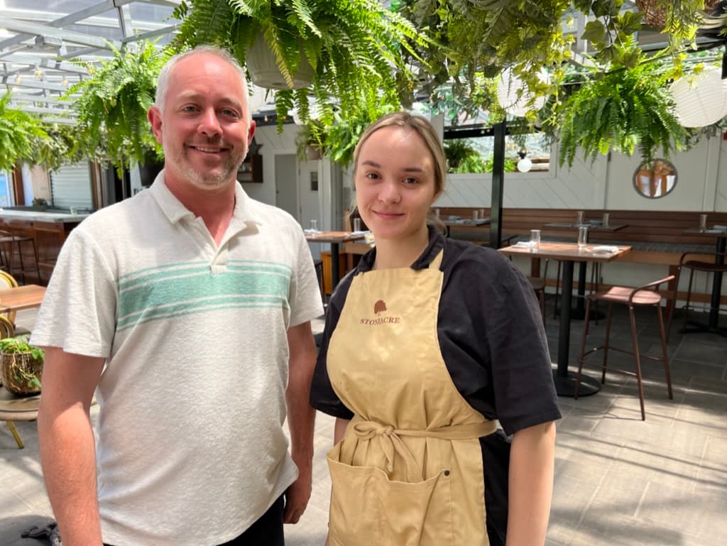 Christopher Bender, the CFO of Stoneacre Hospitality Group, stands next to his employee Vili Pendicheva from Bulgaria.