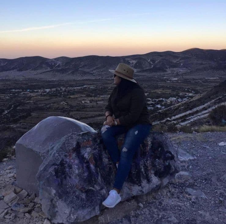 woman on a rock with the sunset