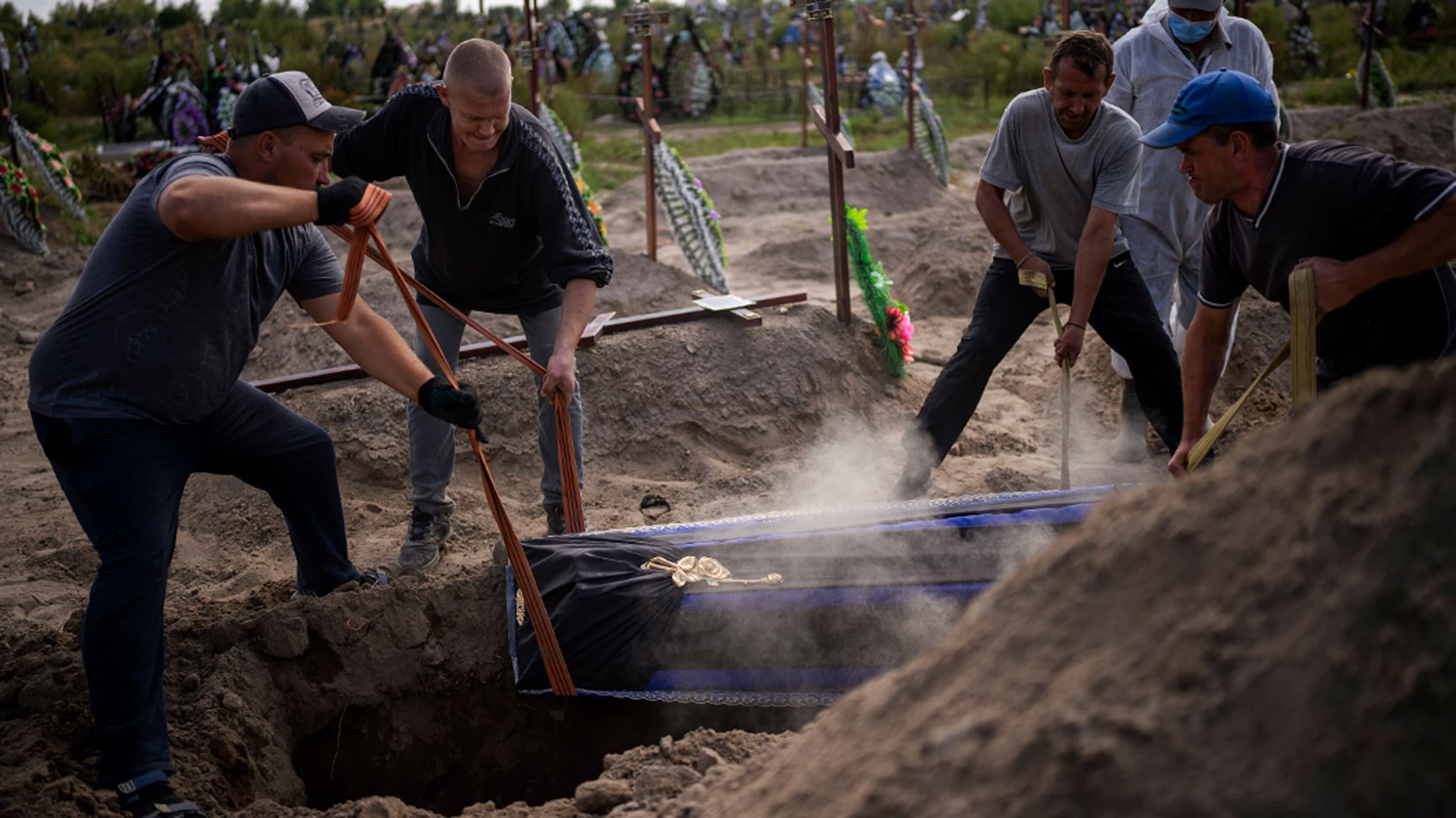 Funeral workers burry a coffin with an unidentified civilian body, who died in Bucha during the Russian occupation period in February-March 2022, during a funeral in Bucha, Ukraine