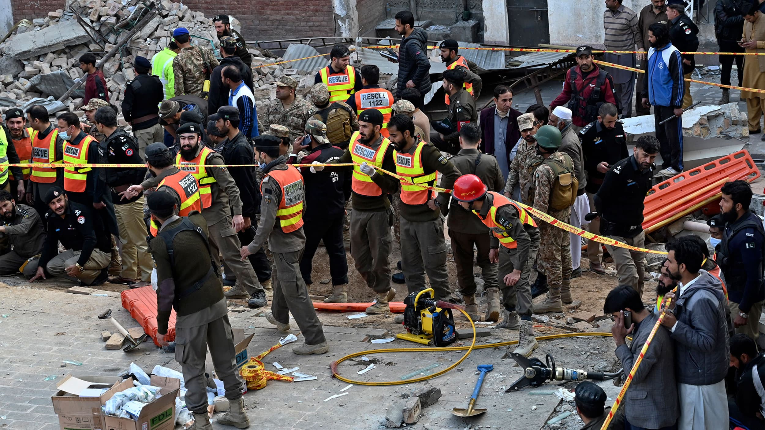 Security officials and rescue workers gather at the site of suicide bombing, in Peshawar, Pakistan