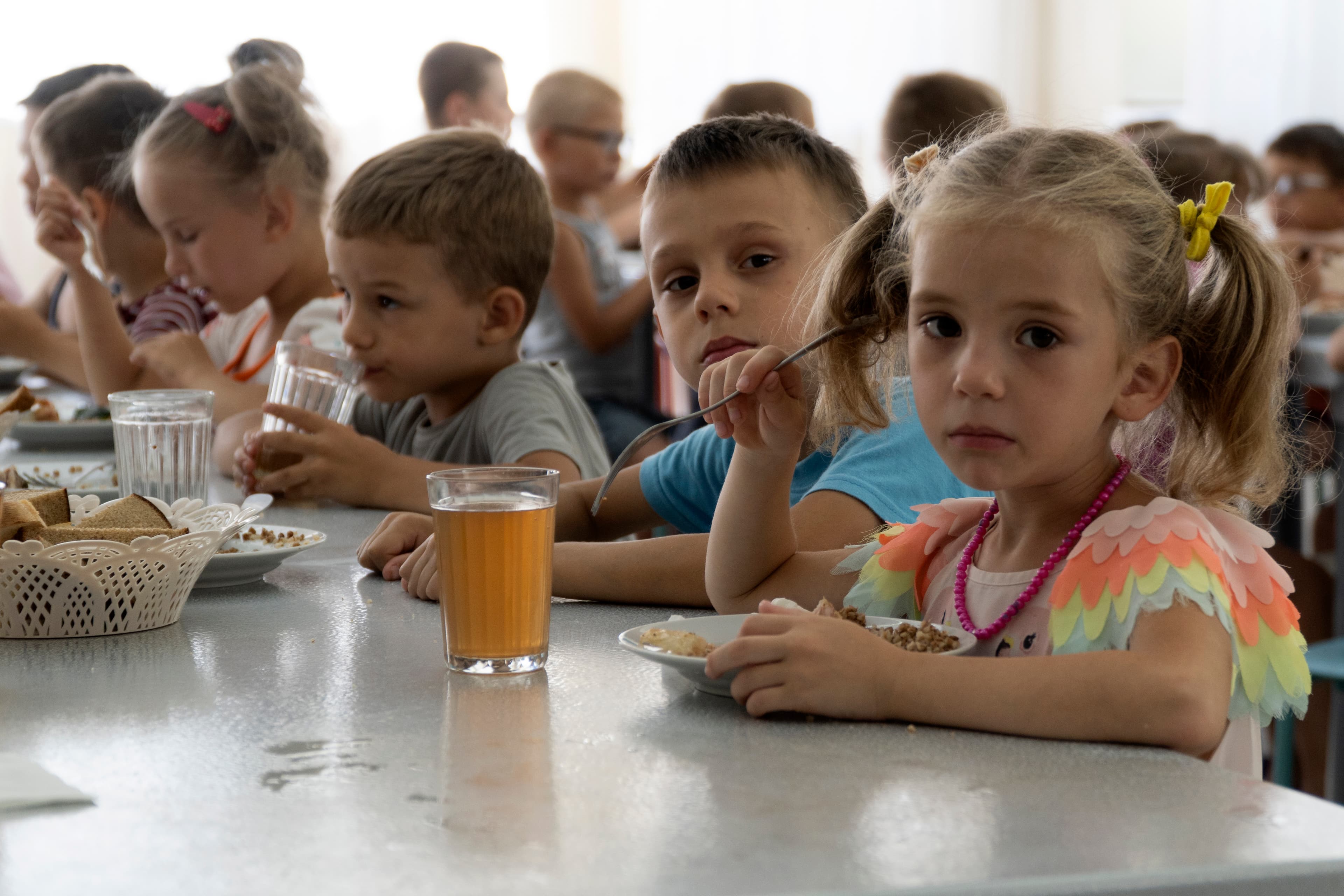 Sad looking children at a cafeteria table
