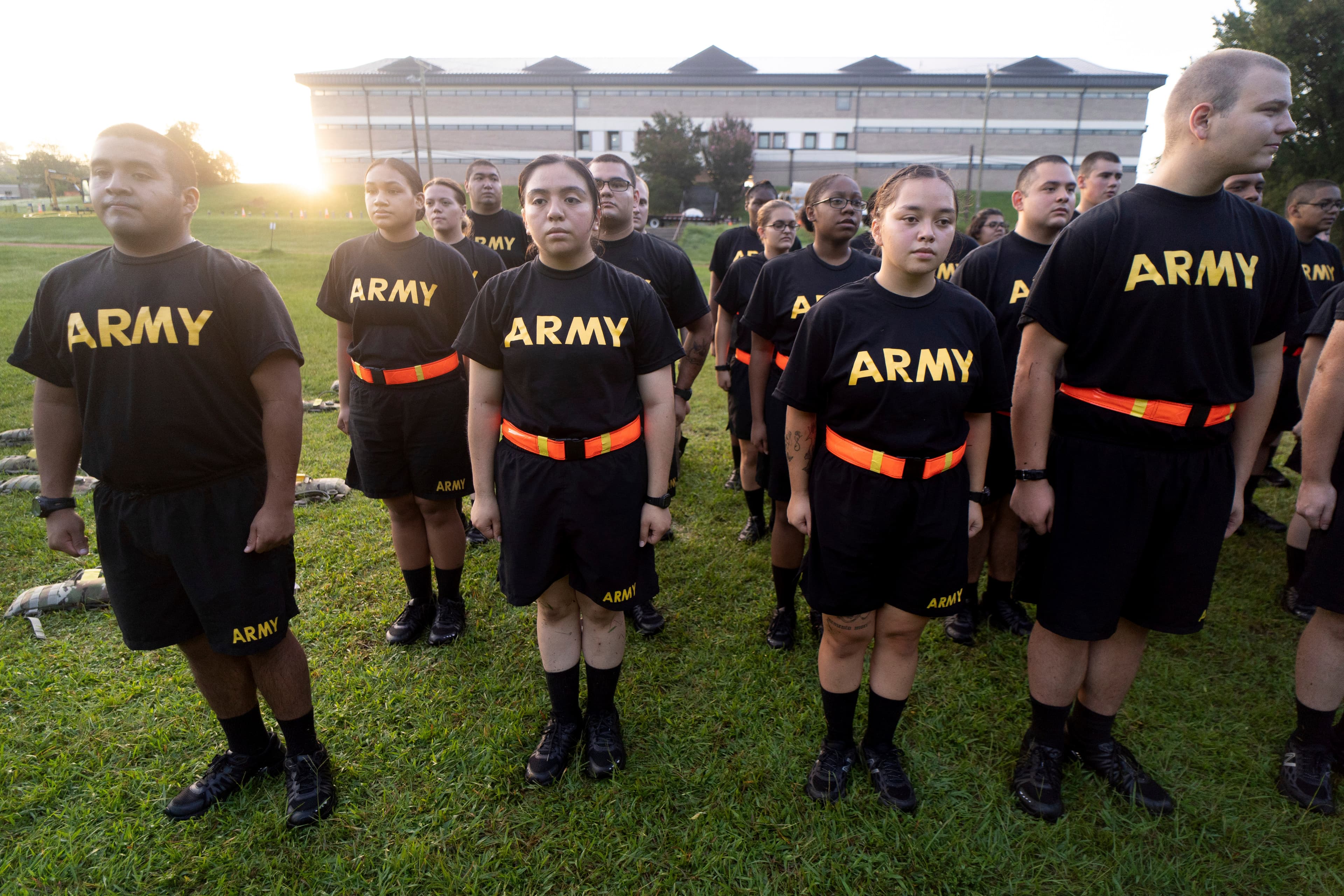 US Army recruits in assumed position, wearing black t-shirts that have "ARMY" written across in bold yellow letters