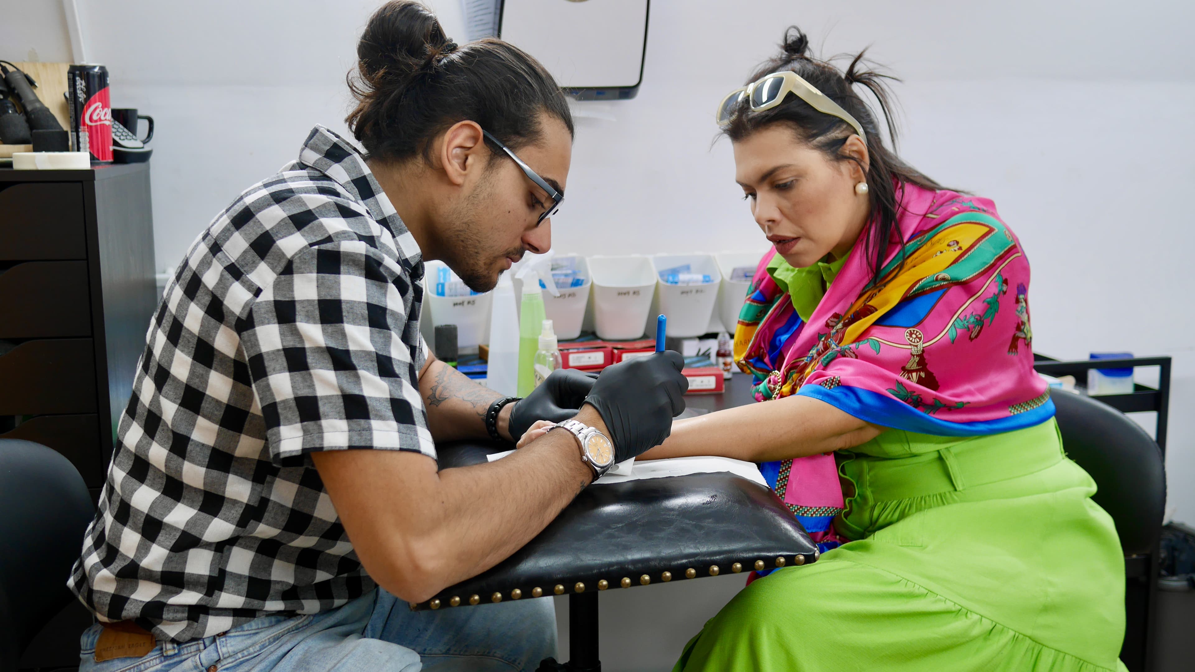 man tattooing woman