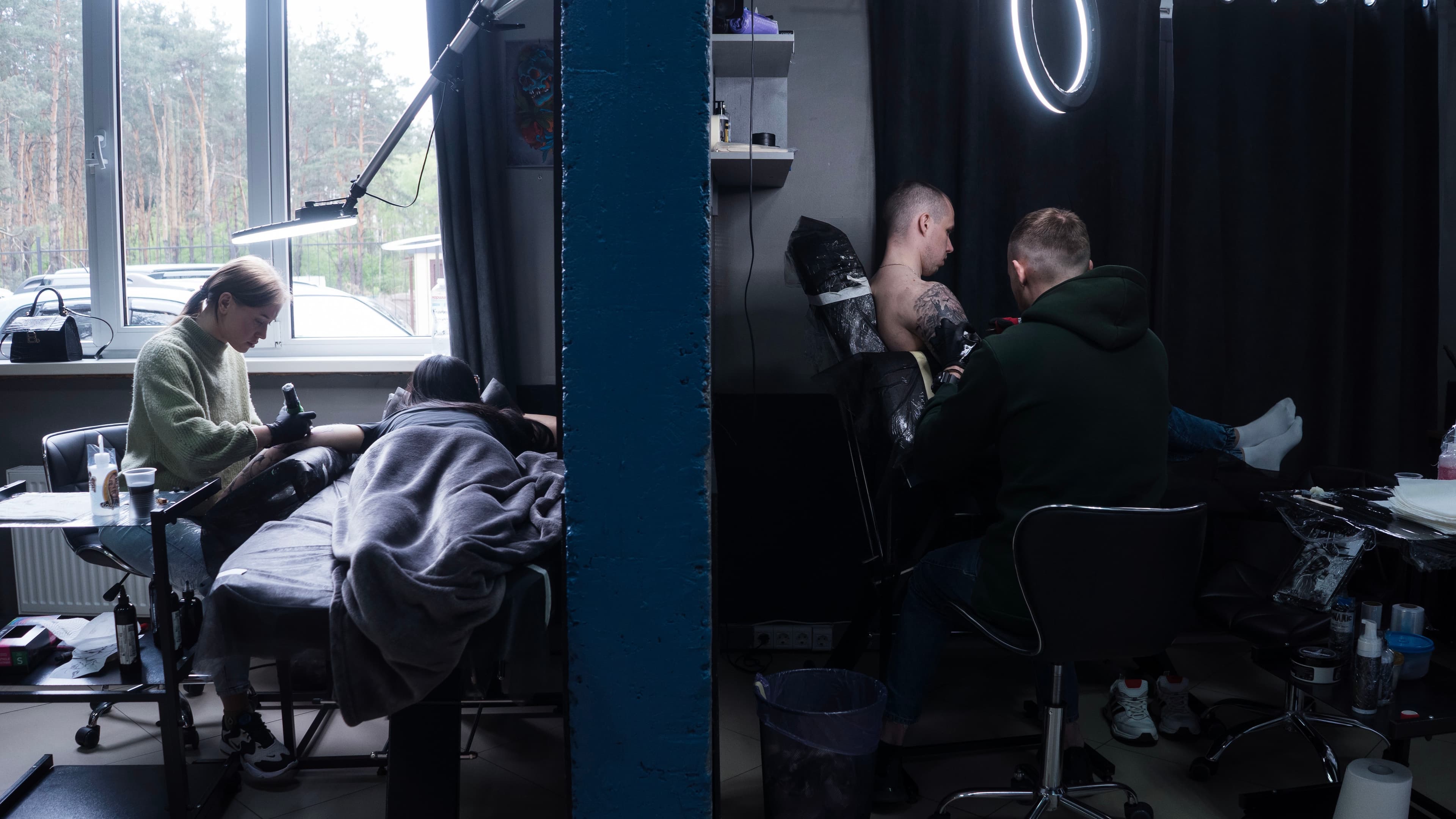 Tattoo artists tattooing their clients.