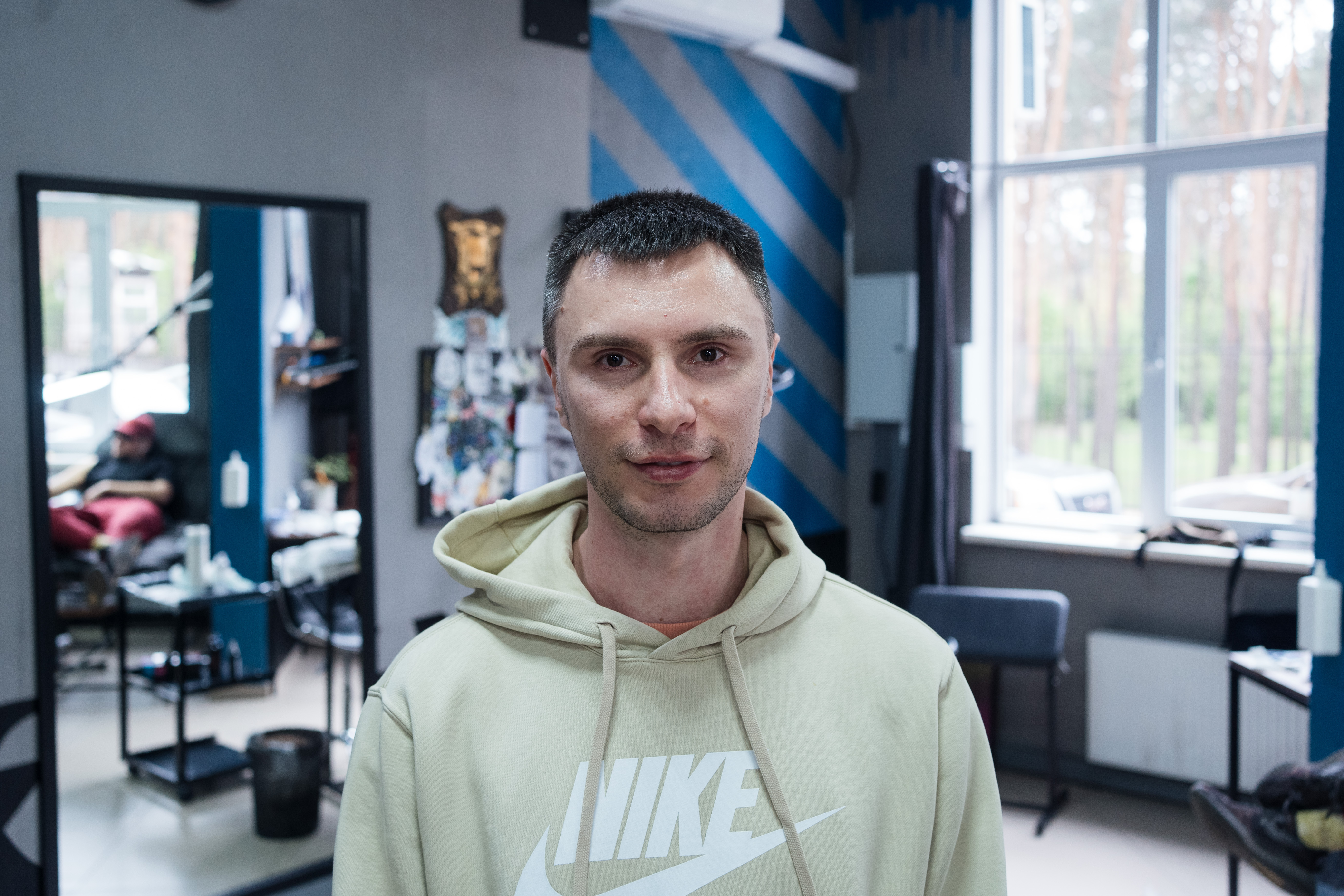 A man standing center frame wearing a lime green nike hoodie