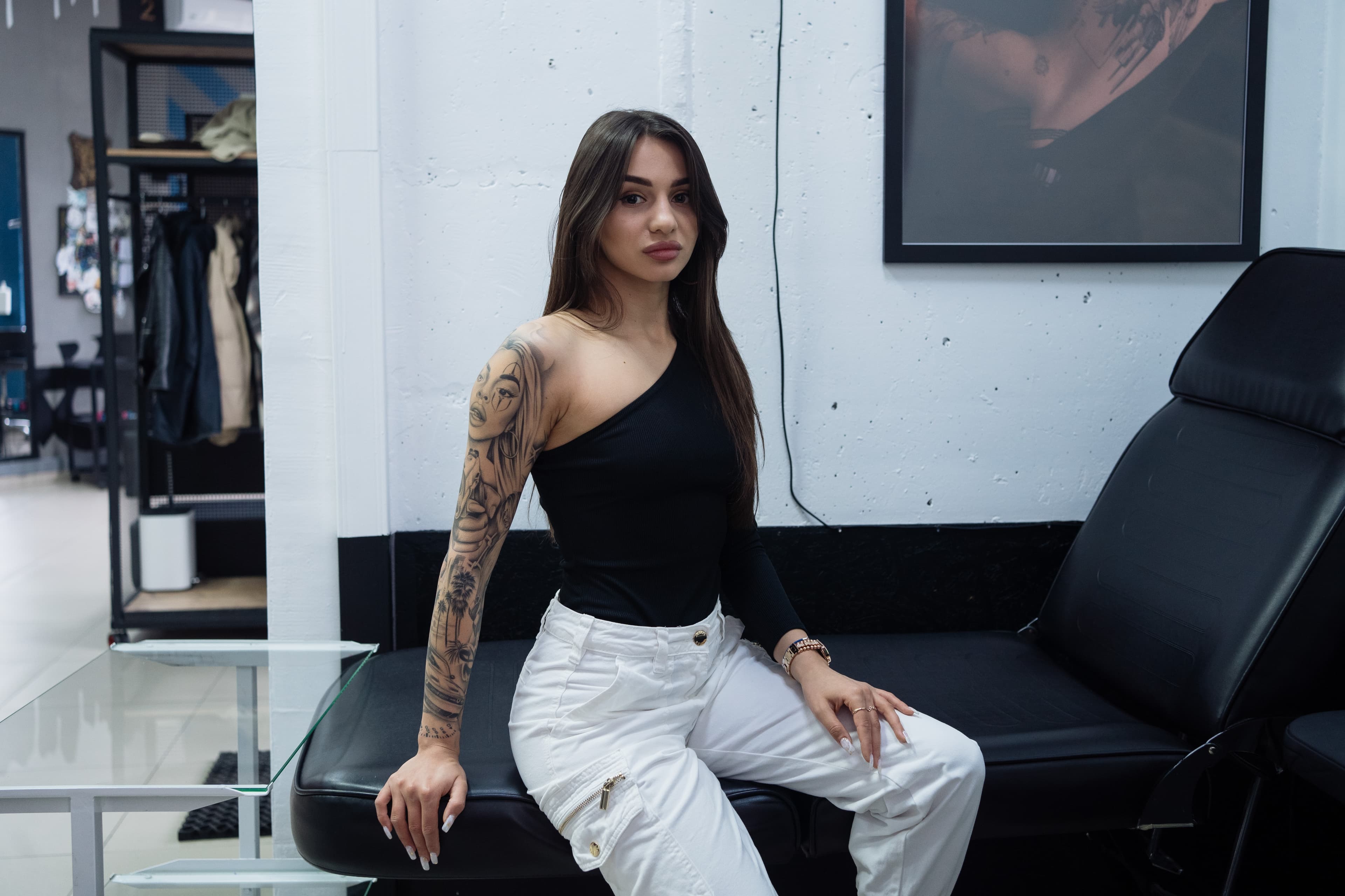 A woman with tattoo sitting on a tattoo bench