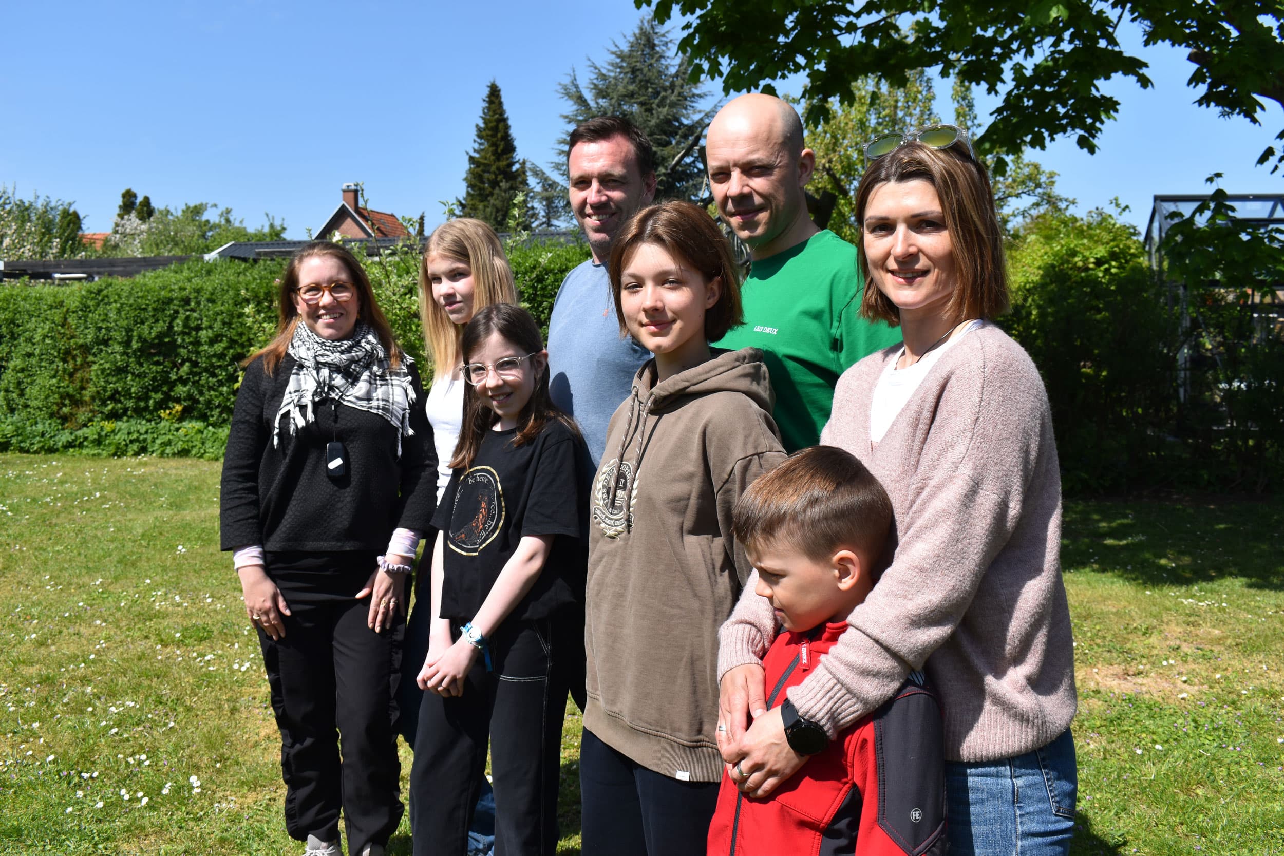 The Olinyks and the Elgaards pose for a photo in the backyard, Hvidovre, Denmark, May 18, 2023.