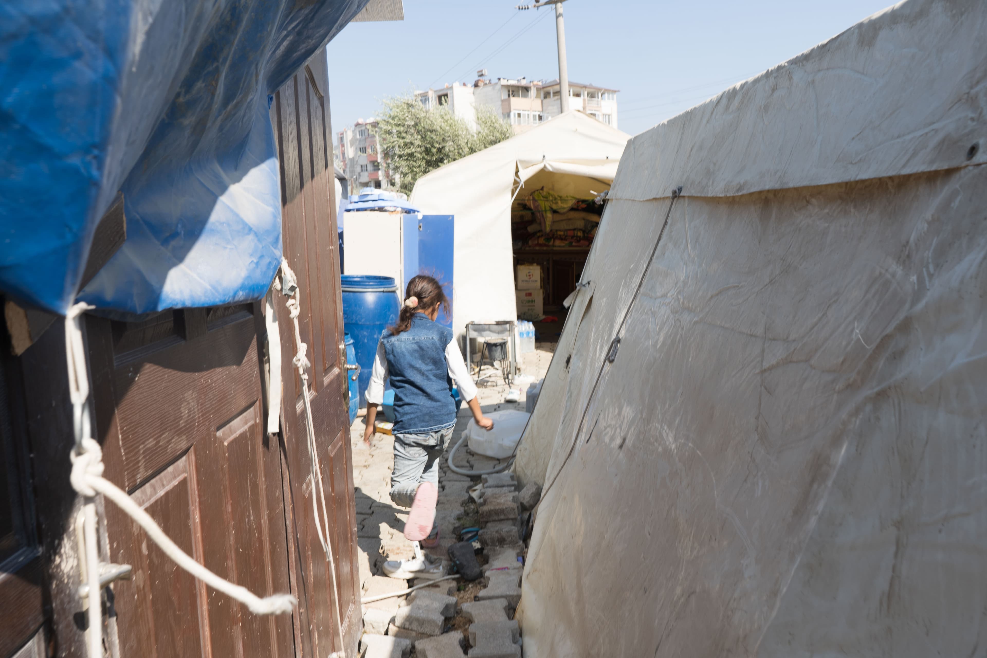 A child walks through a tent camp in an olive orchard in Antakya, Turkey.