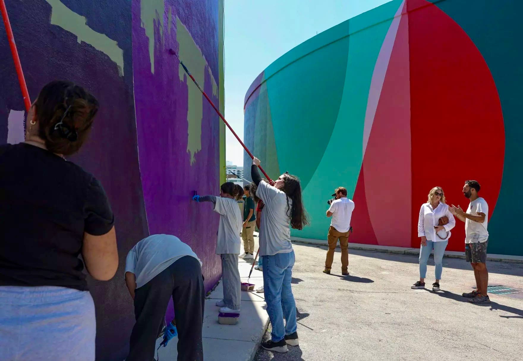 People wearing white shirts and painting