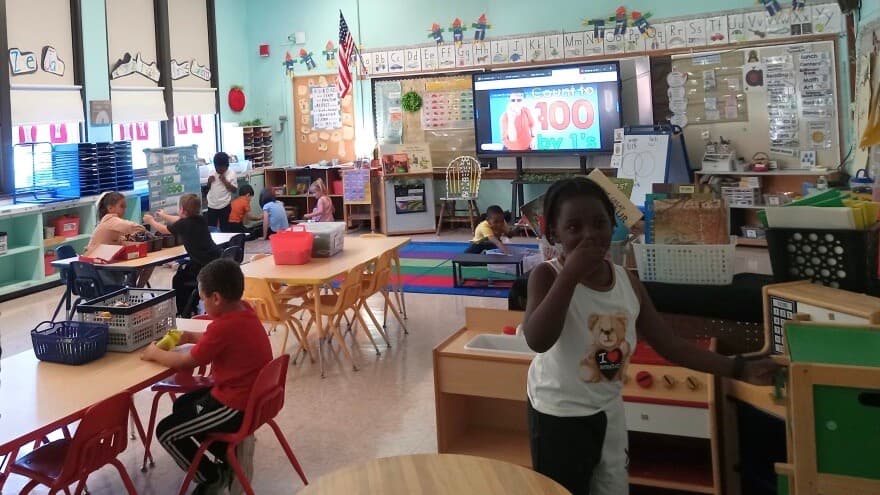 Children all over a colorful classroom
