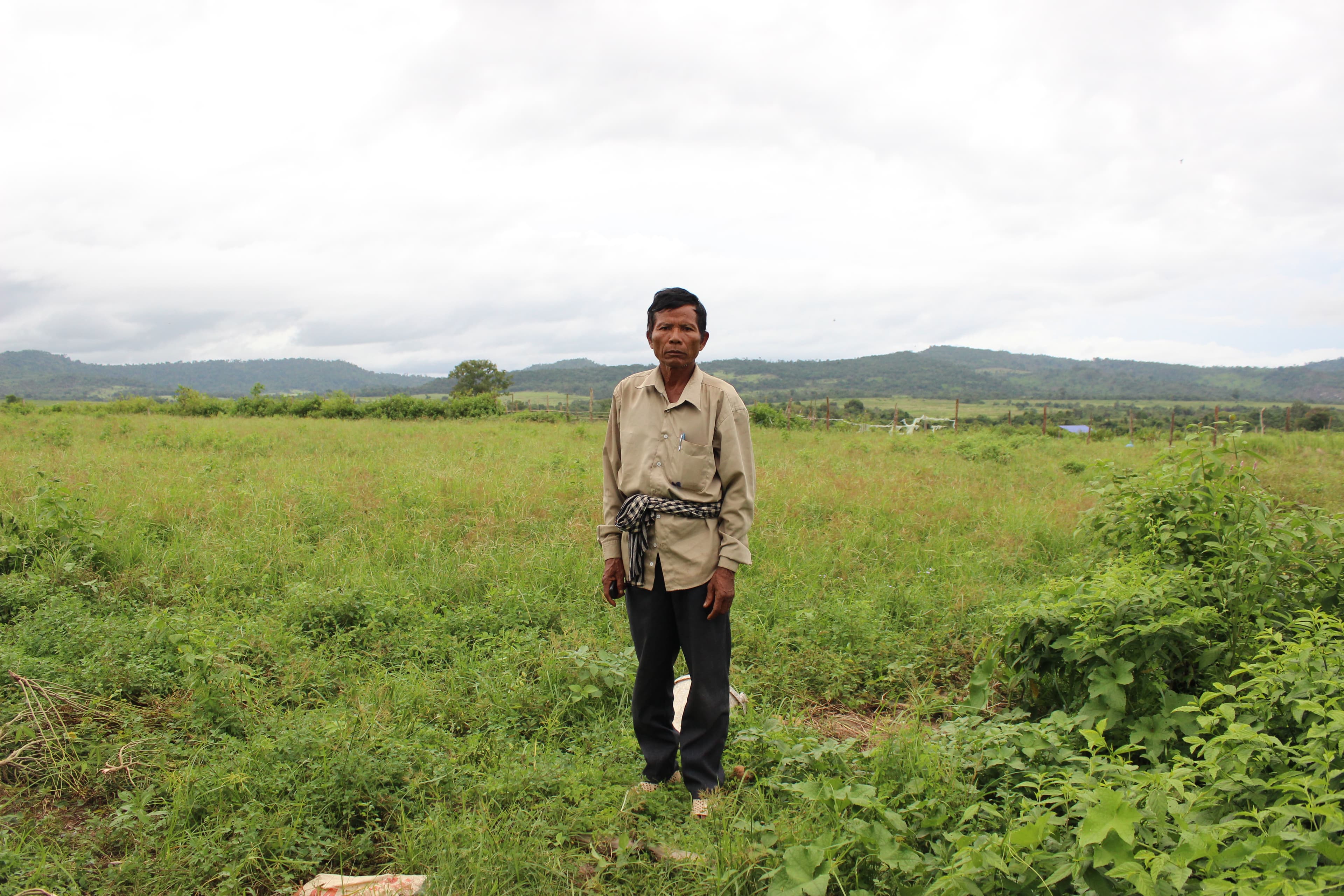 Older male standing on a green field