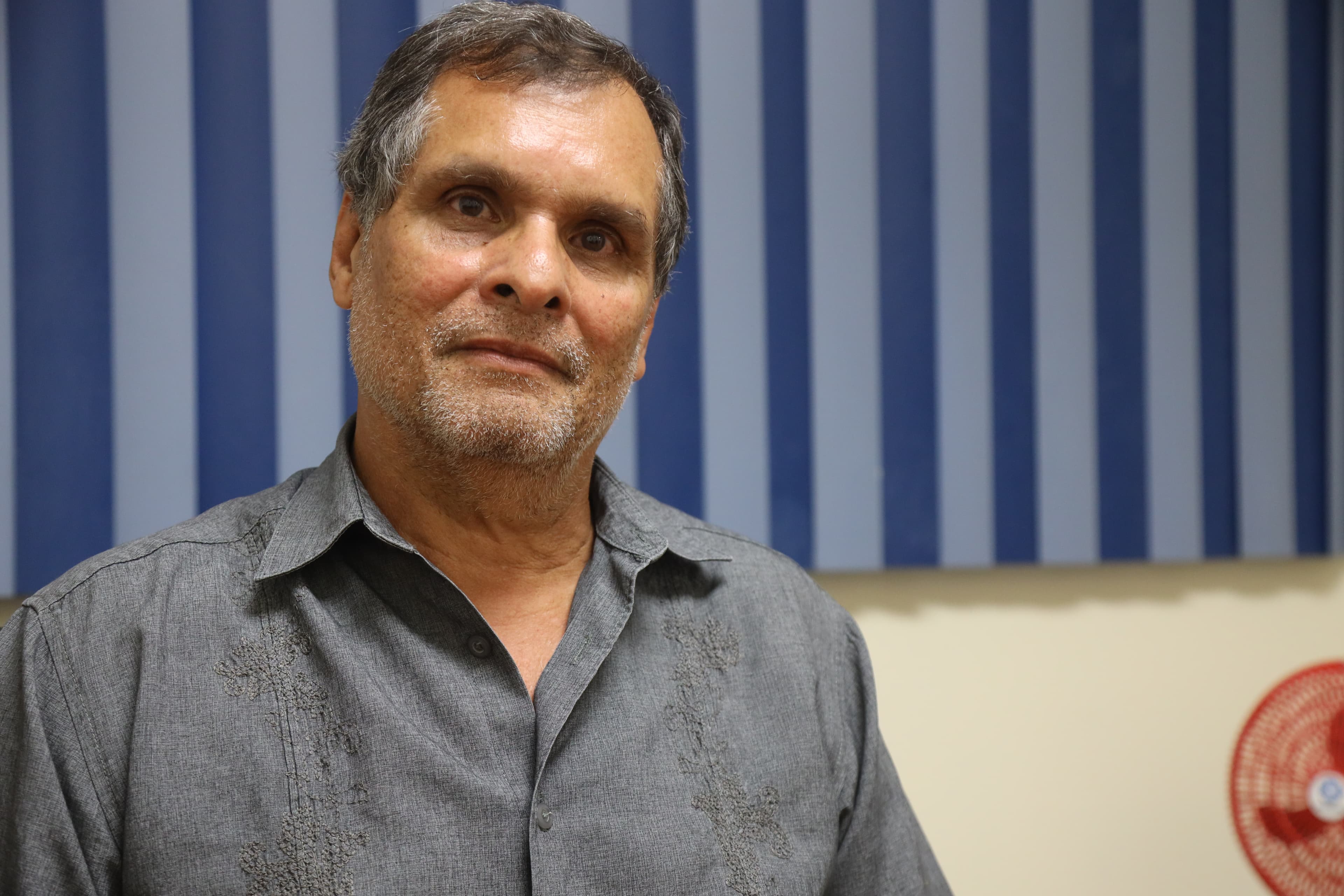 Portrait of a graying man with a gray button up shirt