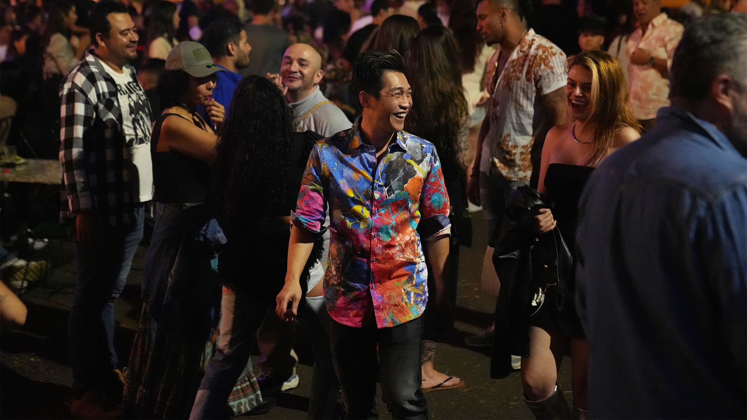 Tourists stroll down a street that is packed with bars and restaurants, in Medellin's Provenza neighborhood.