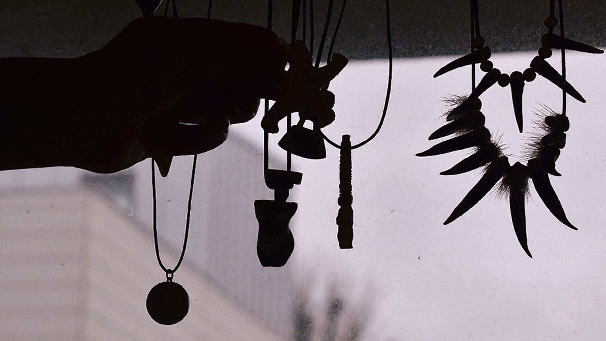 In front of a floor-to-ceiling glass door in the living room of Najannguac Dalgård Christensen, necklaces with amulets carved out of bone and seal claws dangle from a coat hanger.