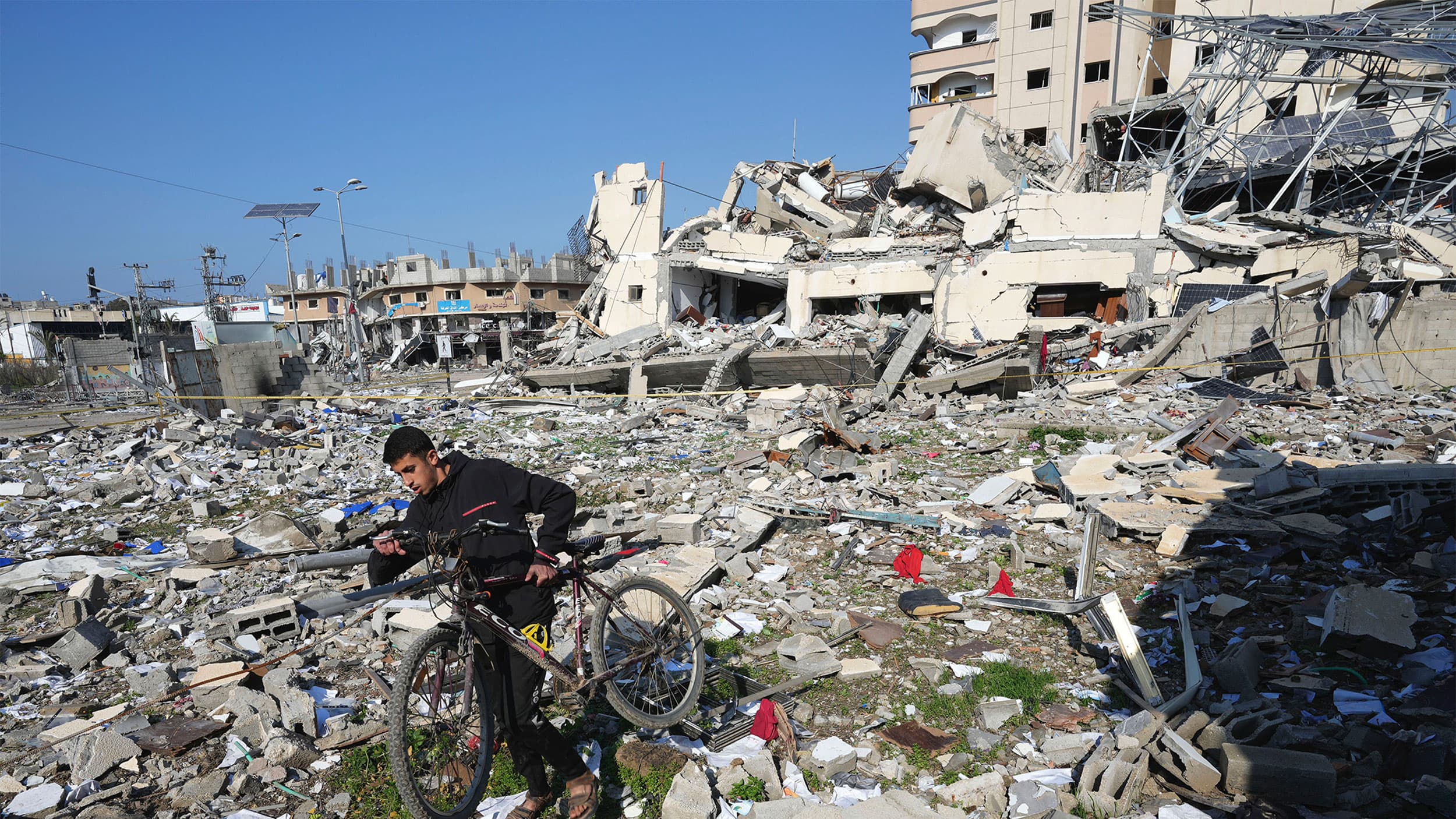 A Palestinian walks through the destruction by the Israeli bombardment in the Nusseirat refugee camp in Gaza Strip, Jan. 16, 2024.