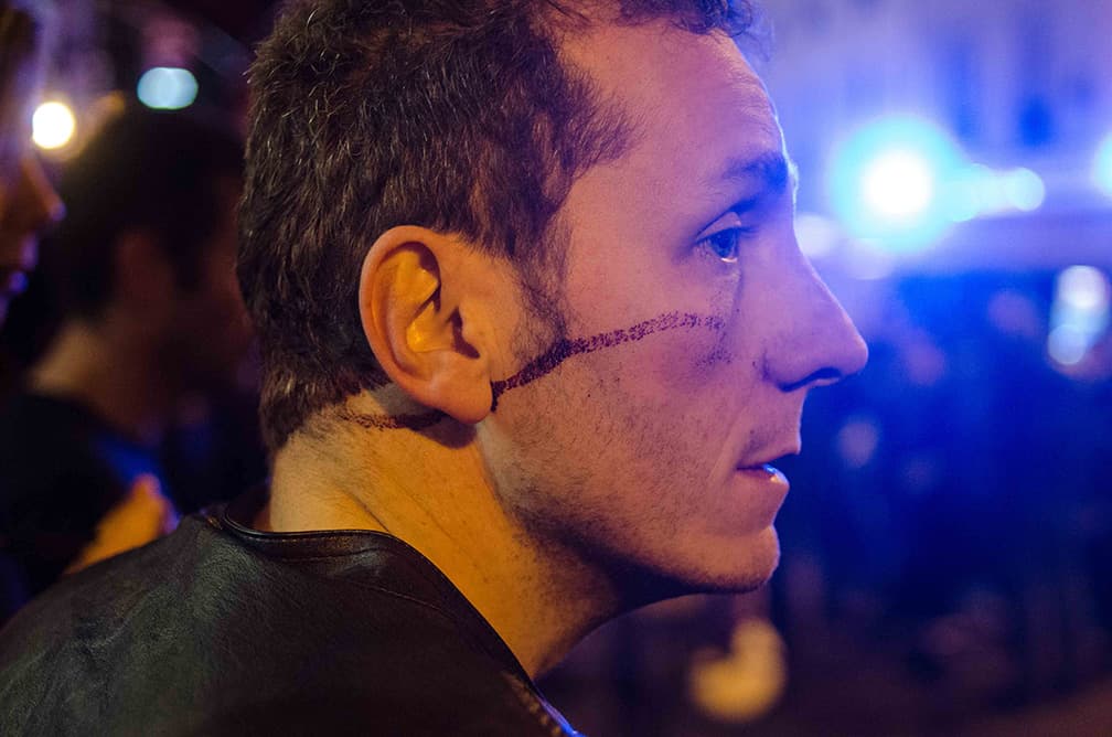 A concert-goer stands on Rue Oberkampf watching the emergency response following the attack on the Bataclan concert hall in Paris on Friday night.