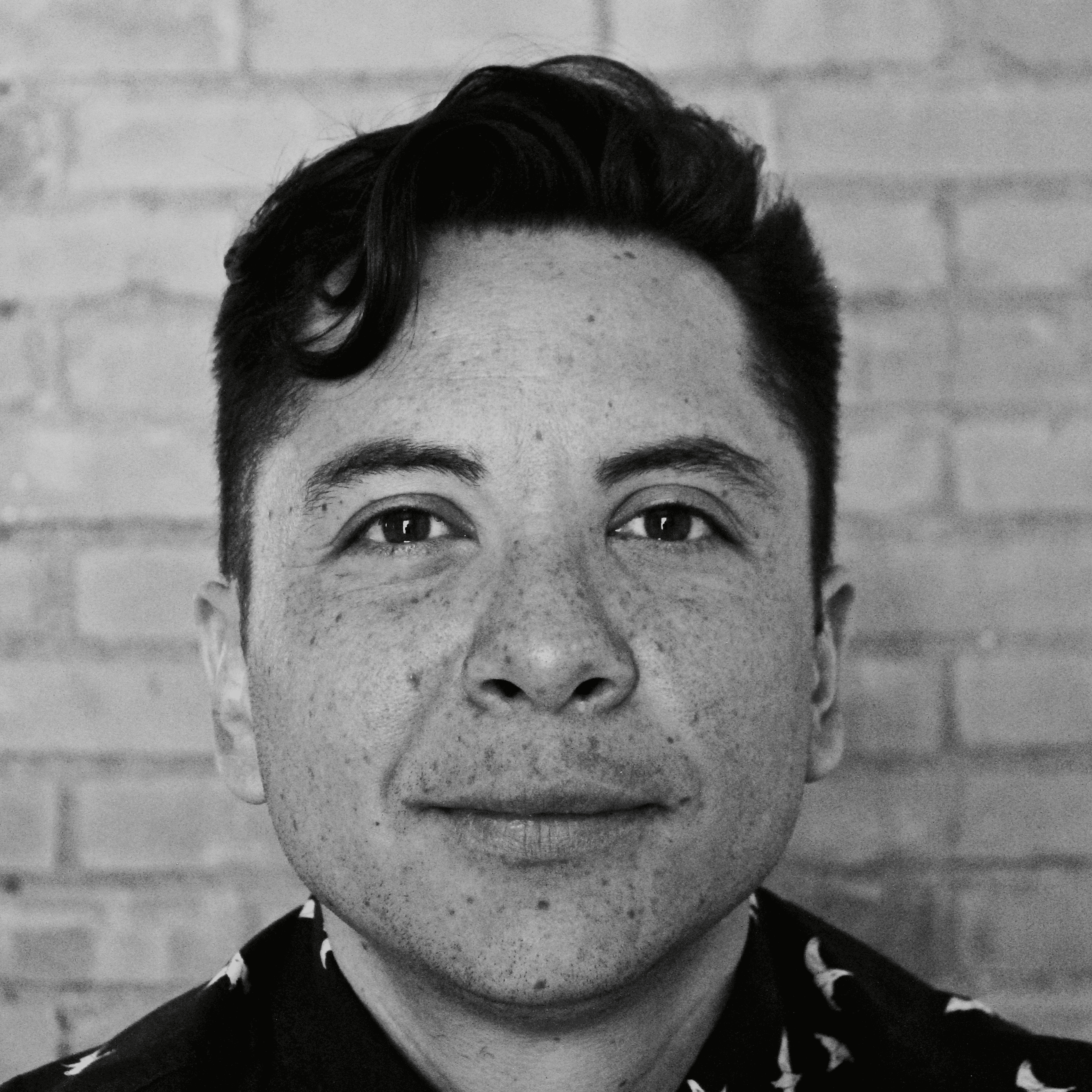 black and white photo of man looking at camera, slight smile