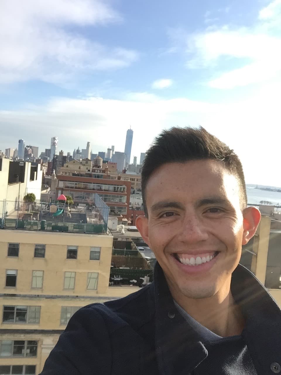 Man on rooftop with view of city