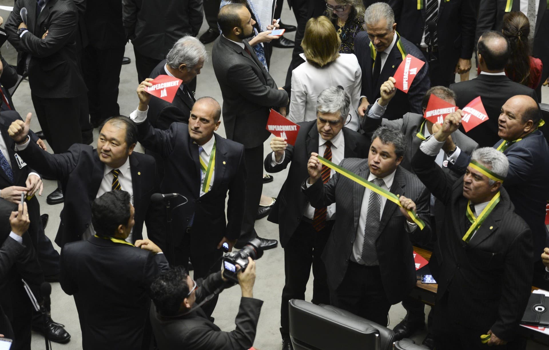 Looking up, congress members hold up impeachment signs.