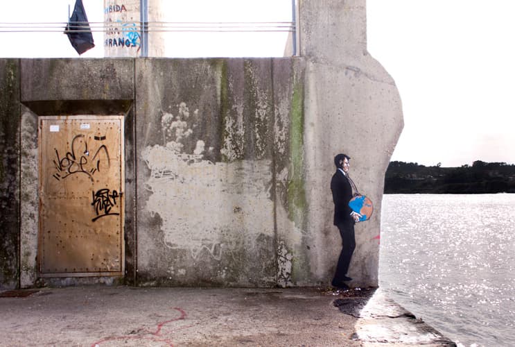 A businessman with a rock tied around his neck, at the edge of Gijon's port. A clear commentary on how Spain’s economy was sunk by real estate speculators.