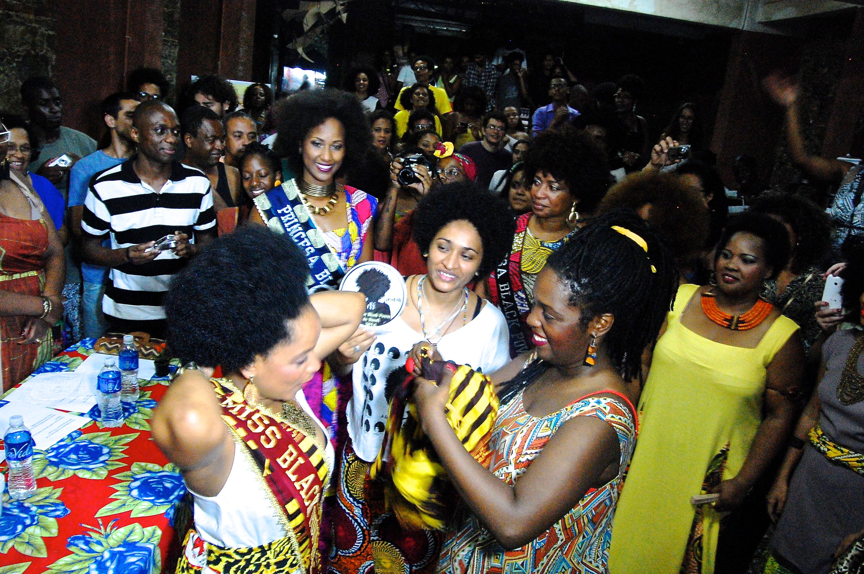 Ana Paula Mendonça and Isabel Freitas crown Maria Priscila the first Miss Black Power Brazil with a yellow turban, chosen because it is the color of Oxum, the African mythological and religious figure that signifies female power. Runners-up Elaine Serafim
