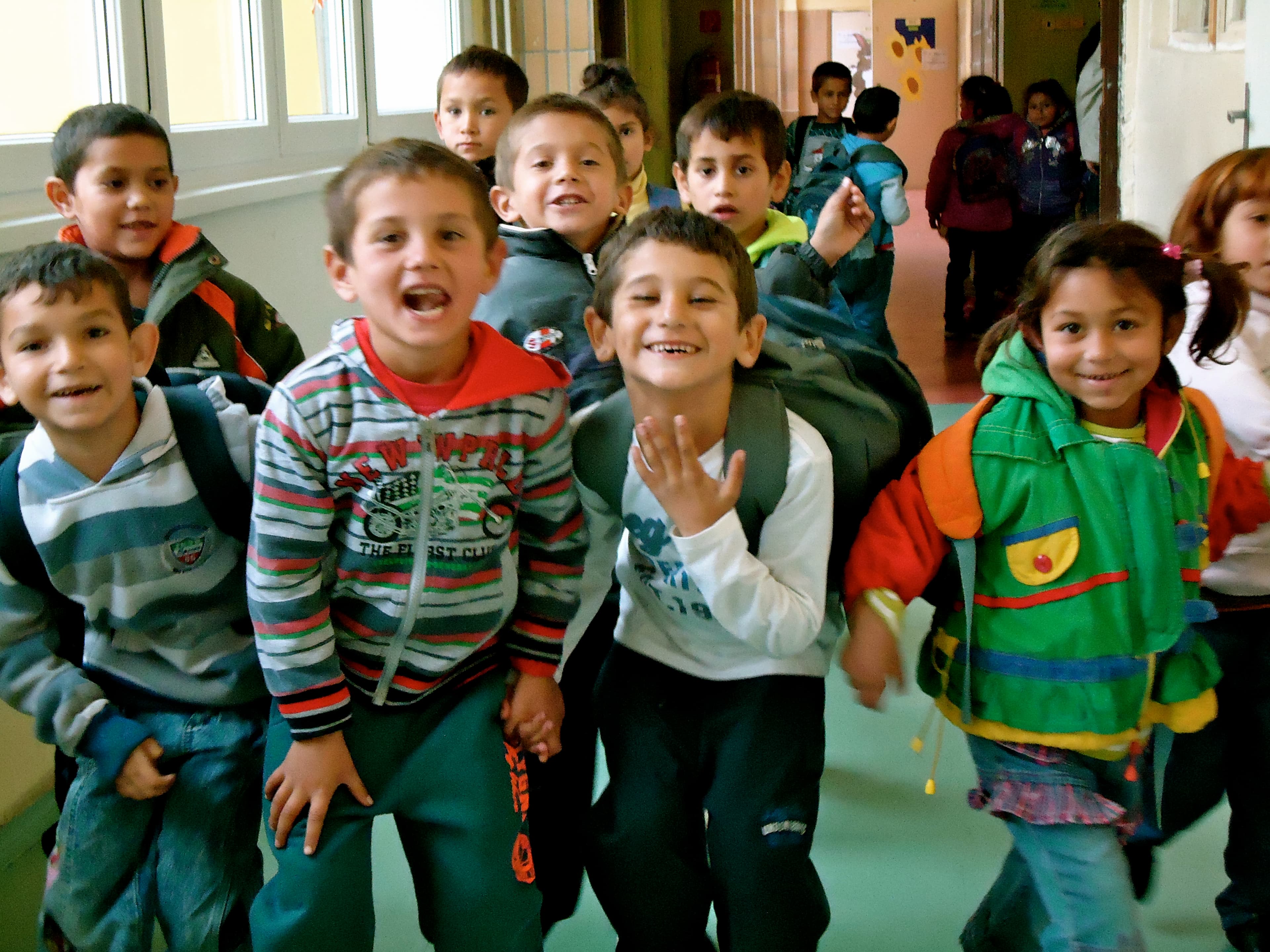 A group of young Roma students goof off in the hallway of Šarišské Michaľany elementary school.