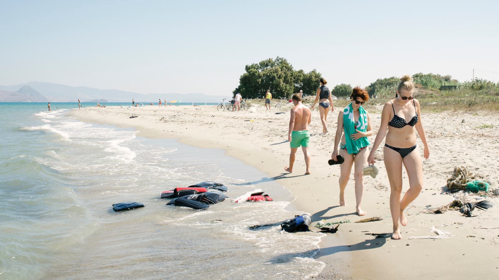 Tourists walk past life preservers on the beaches of Kos, Greece.