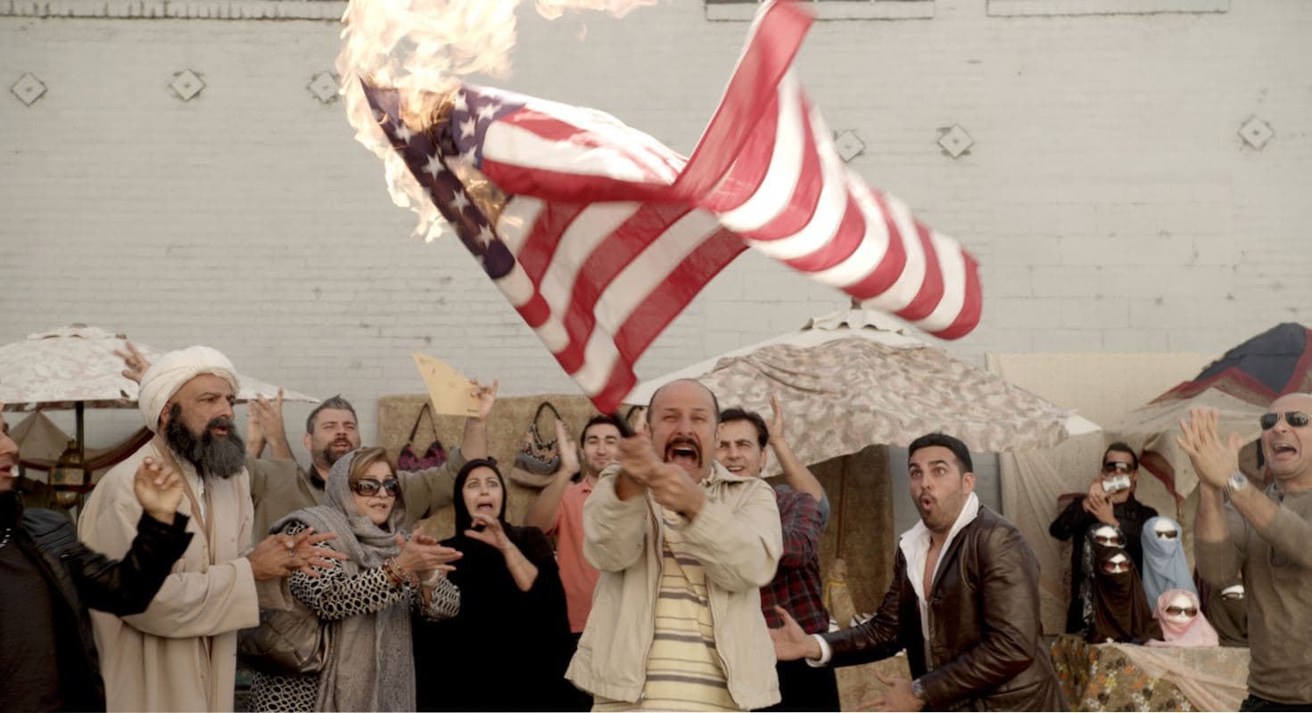 Maz Jobrani's character Jimmy Vestwood, an Iranian, panics when during a party to celebrate his winning a Green Card Lottery visa to the United State, his American flag is accidentally set on fire from a cigarette butt flicked into his yard by a neighbor.