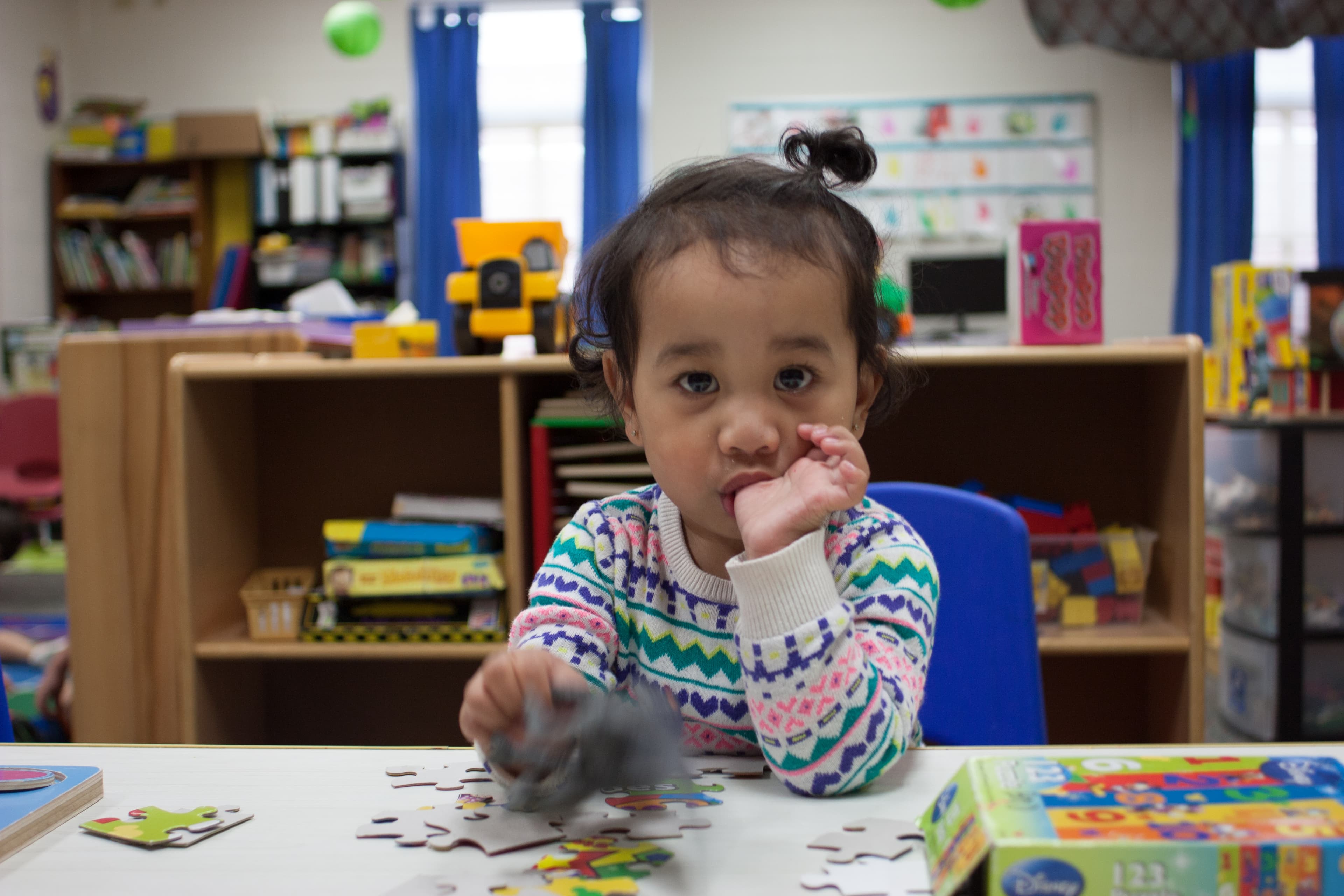 Child looks at camera while sucking thumb