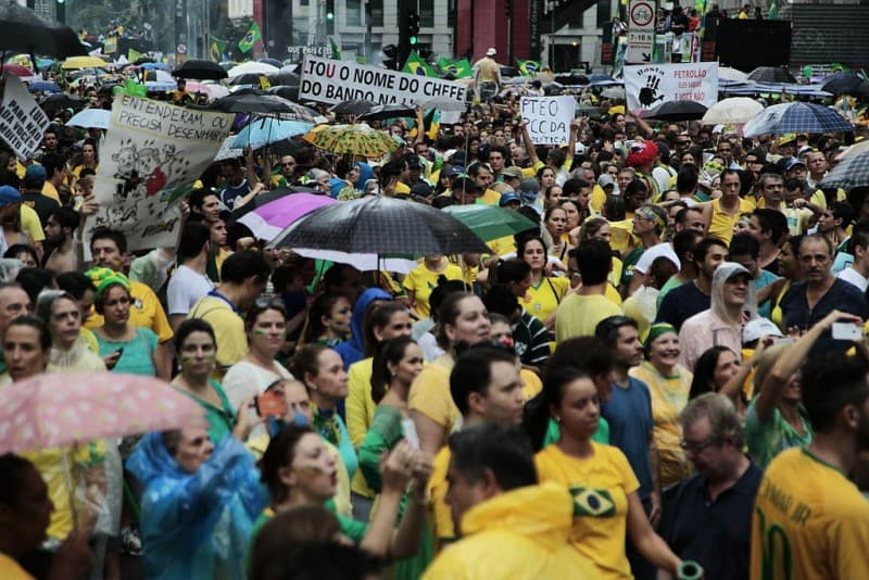 crowd of protesters with umbrellas and signs