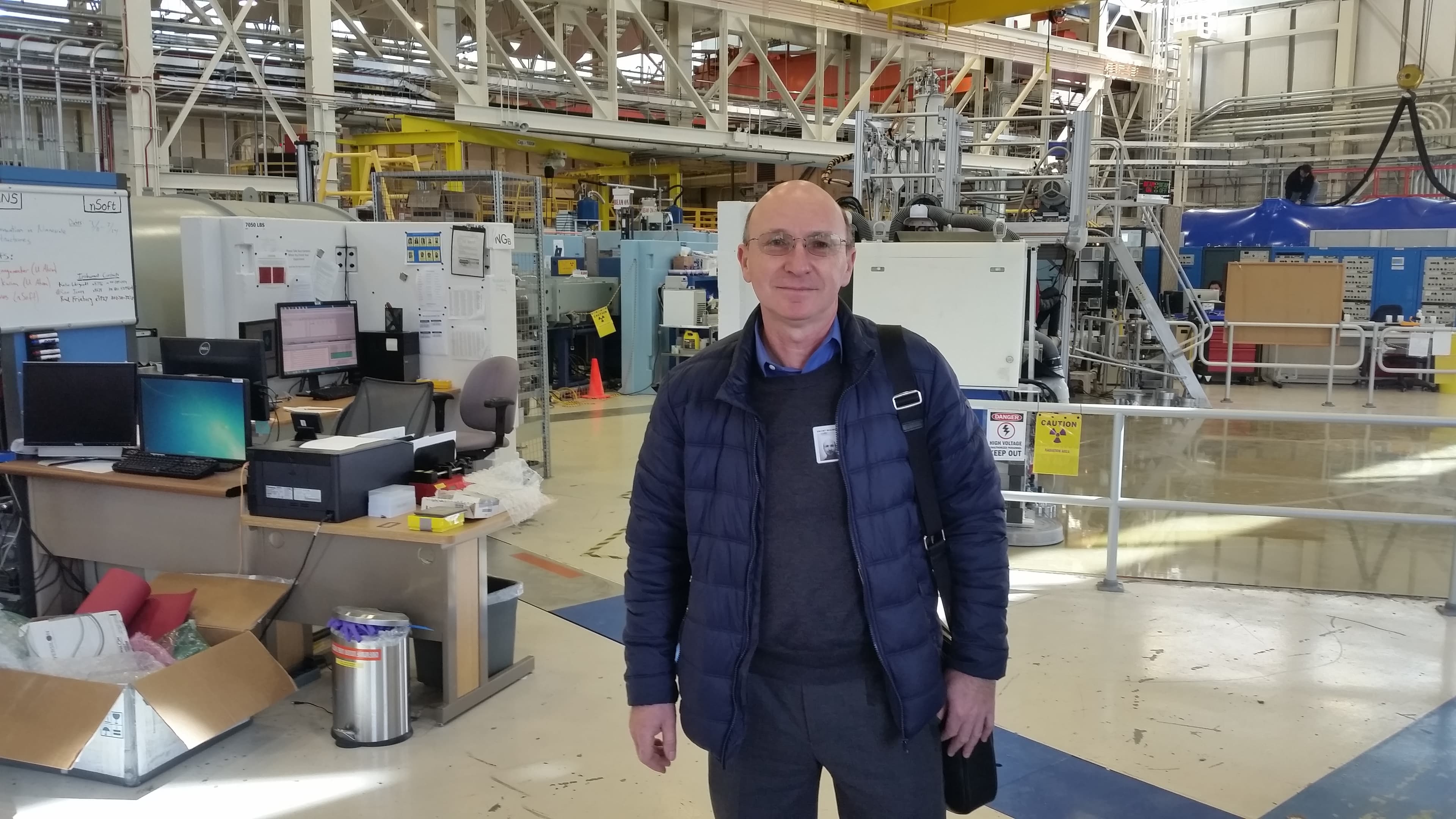 Man poses in front of lab equipment