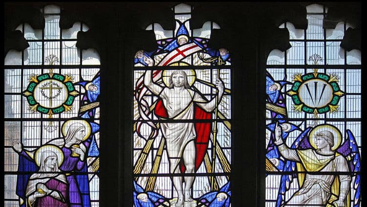 Colorful stained-glass windows depicting the resurrection of Jesus Christ at Sherborne Abbey in Dorset, England.