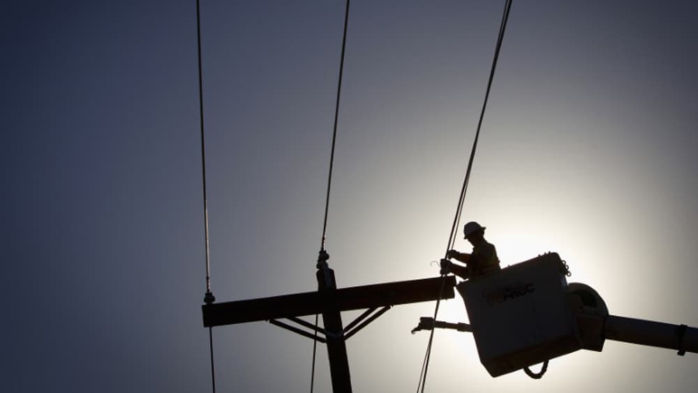 An electrical line technician works on restoring power in Vilonia, Arkansas.