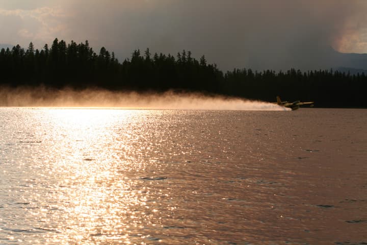 A firefighting plane skims the surface of a lake in Montana