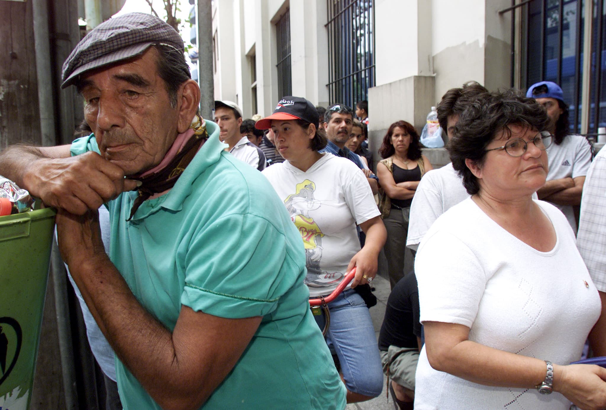 Unemployed Argentines and workers line up outside the Banco de la Nacion in Buenos Aires trying to collect their money, December 21, 2001. Argentina would default on its sovereign debt days later.