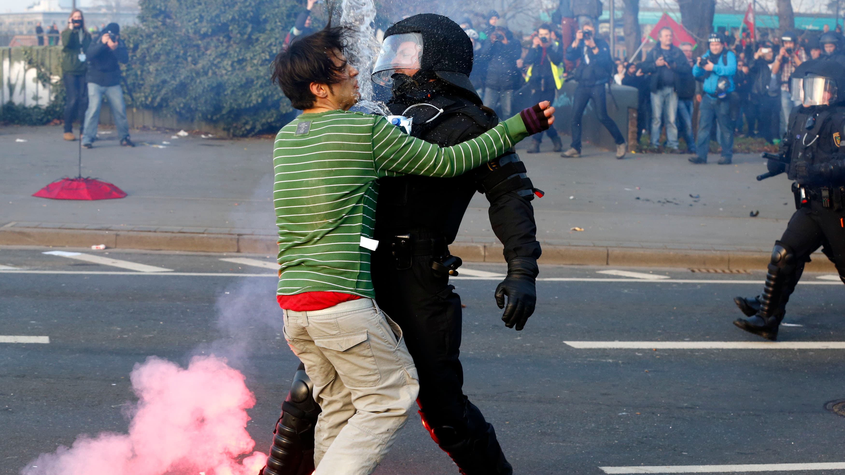 A policeman stops a 'Blockupy' anti-capitalist protester near the European Central Bank building before the official opening of its new headquarters in Frankfurt.