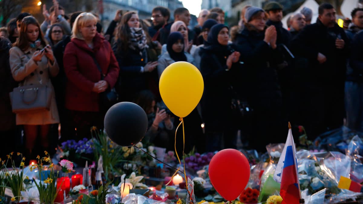 People gather at the Place de la Bourse to pay tribute to the victims of bomb attacks in Brussels.