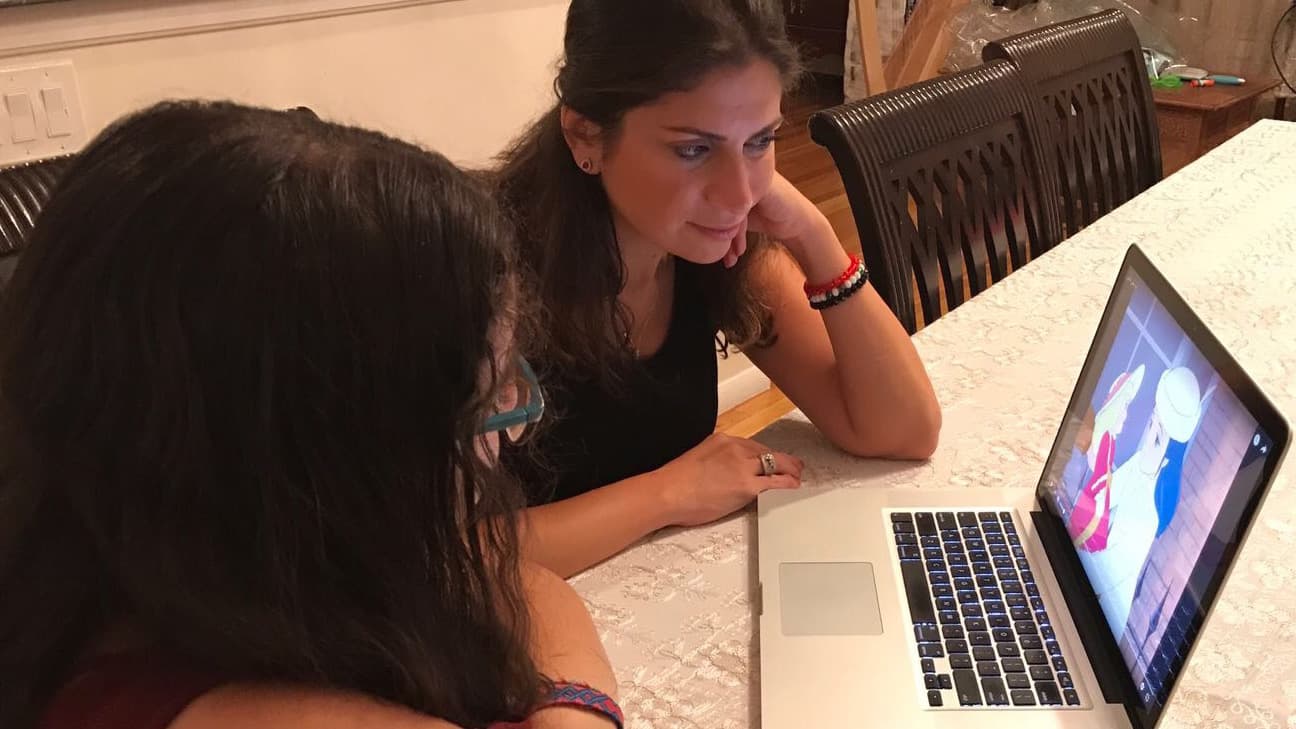 Dima Basha (right) watches dubbed cartoons with her daughter, Angelina, to help her learn formal Arabic.