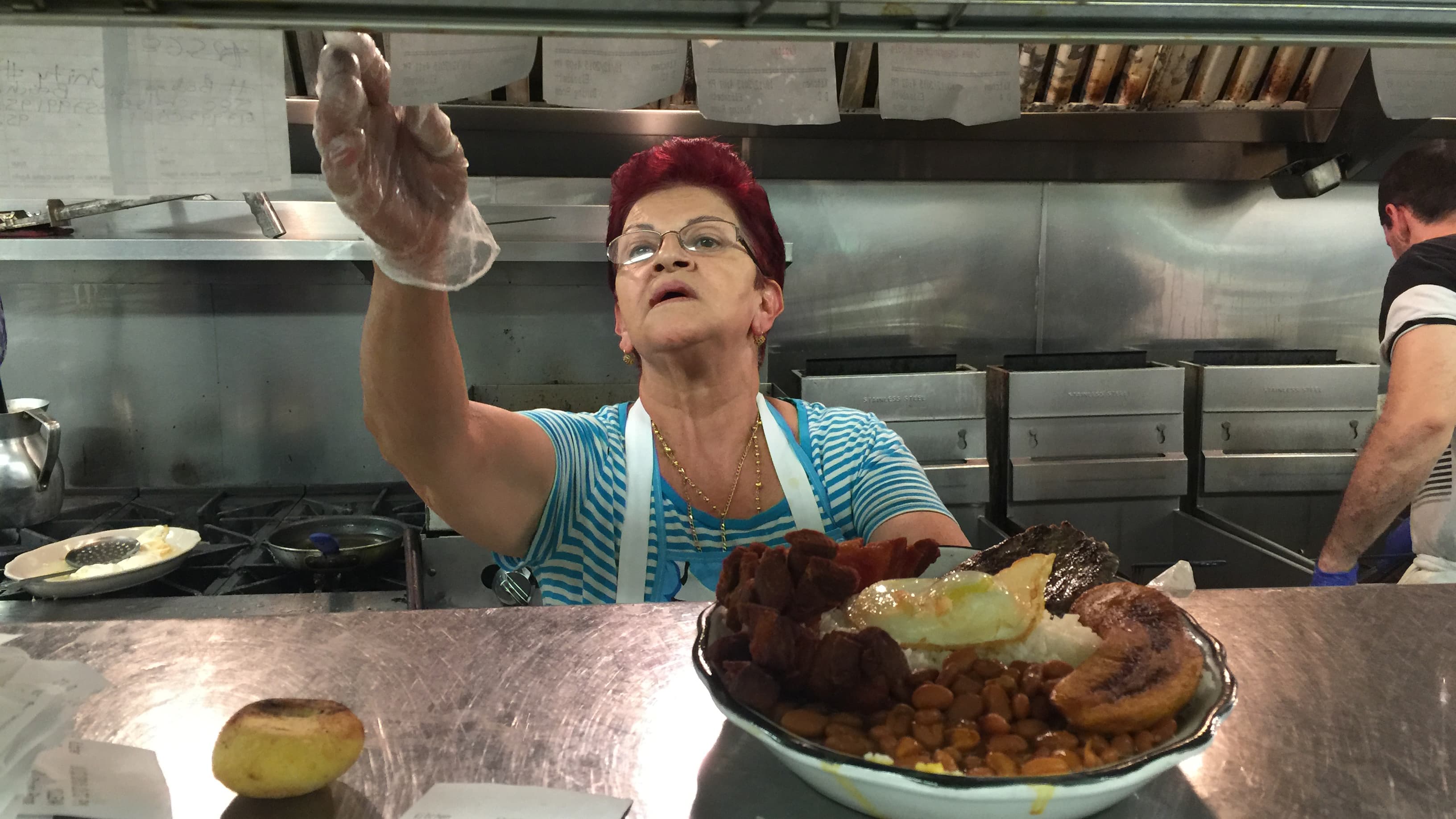 The owner of El Peñol restaurant in East Boston with a bandeja paisa.